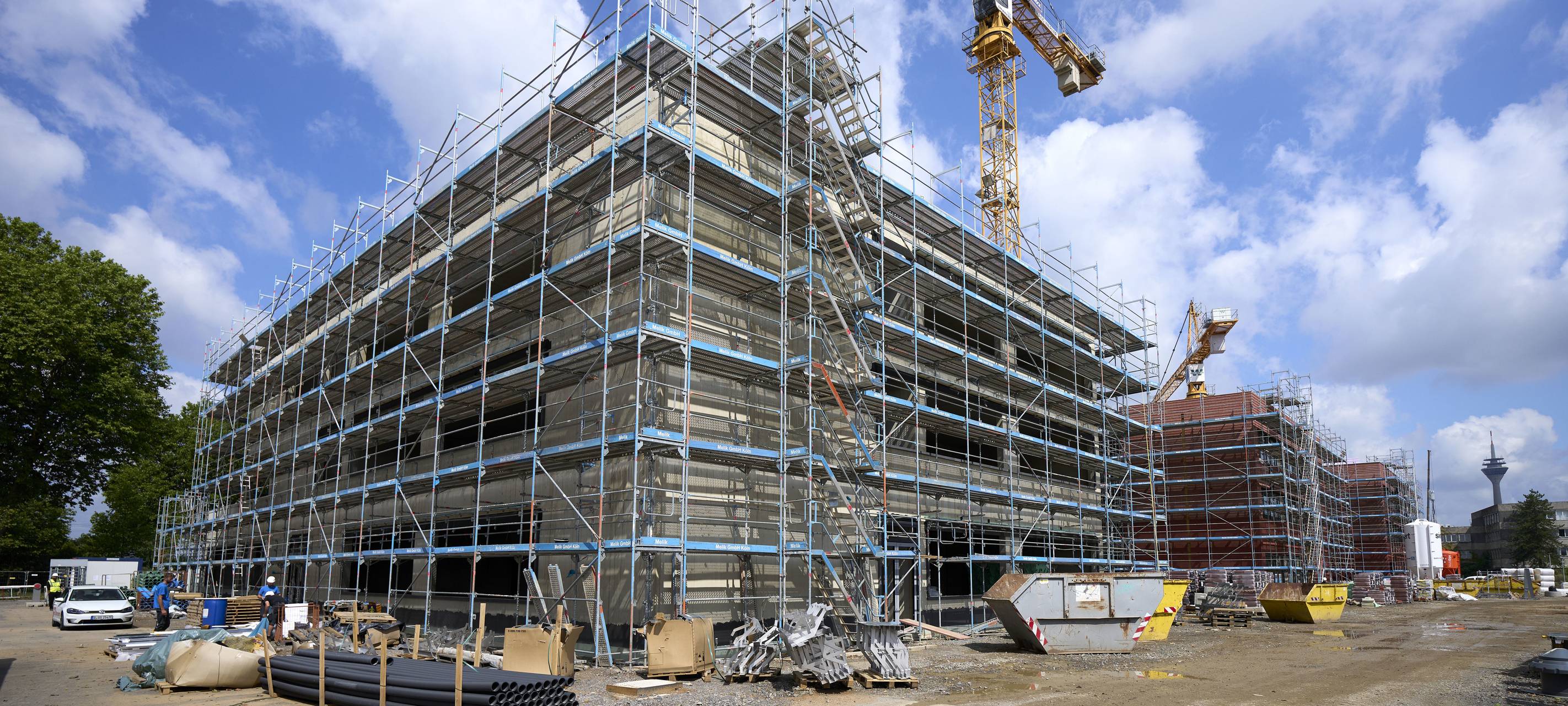 Auf der Baustelle ist das neue Luisengymnasium an der Völklinger Straße noch eingerüstet. Inmitten der Gebäude steht ein Baukran.