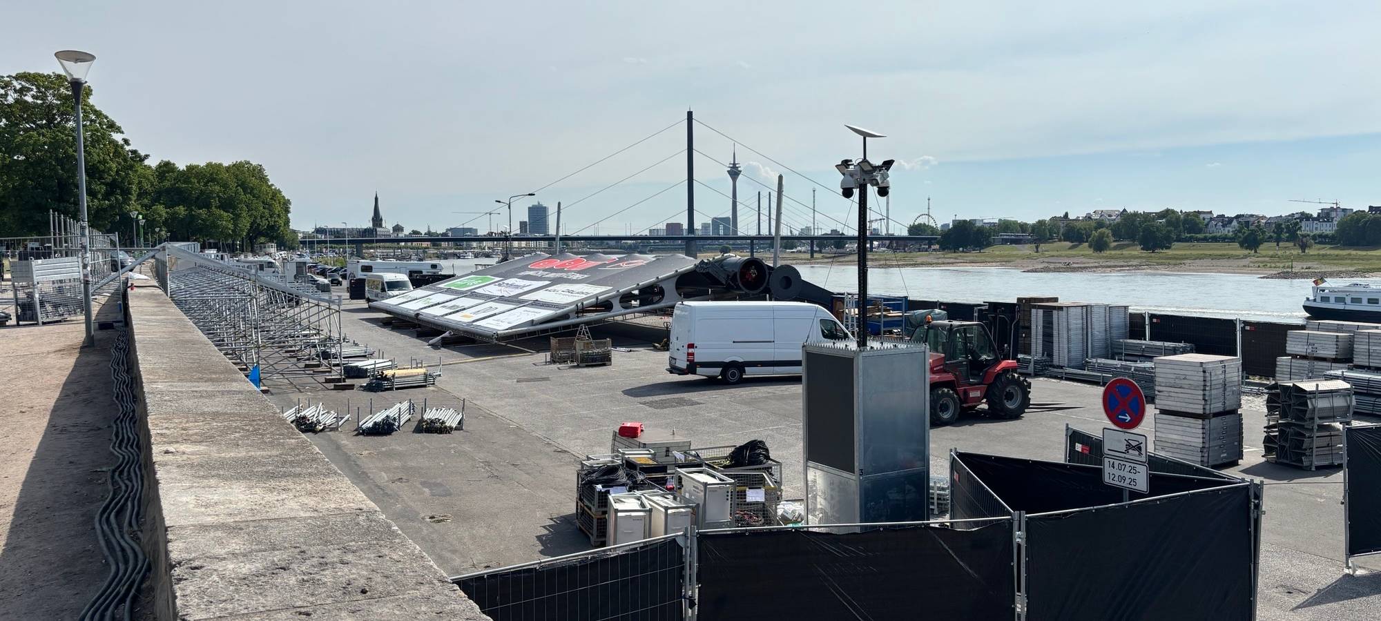 Am Robert-Lehr-Ufer beginnen die Aufbauarbeiten für das Open Air Kino. Die Tribüne steht zur Hälfte und die Leinwand liegt auf dem Boden.