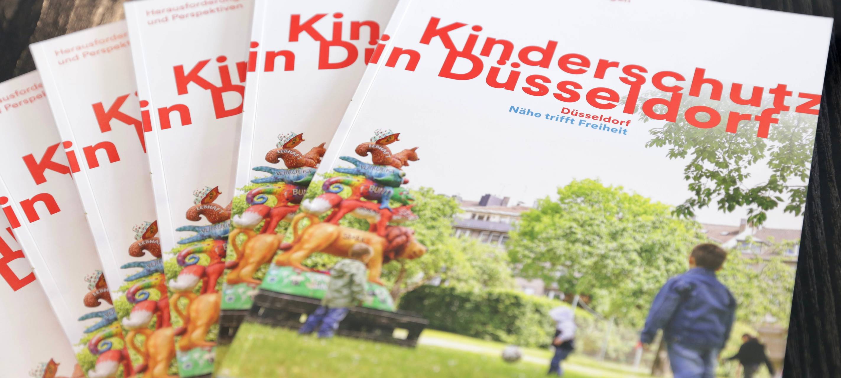 Die neue Broschüre "Kinderschutz in Düsseldorf" liegt auf einem Tisch.