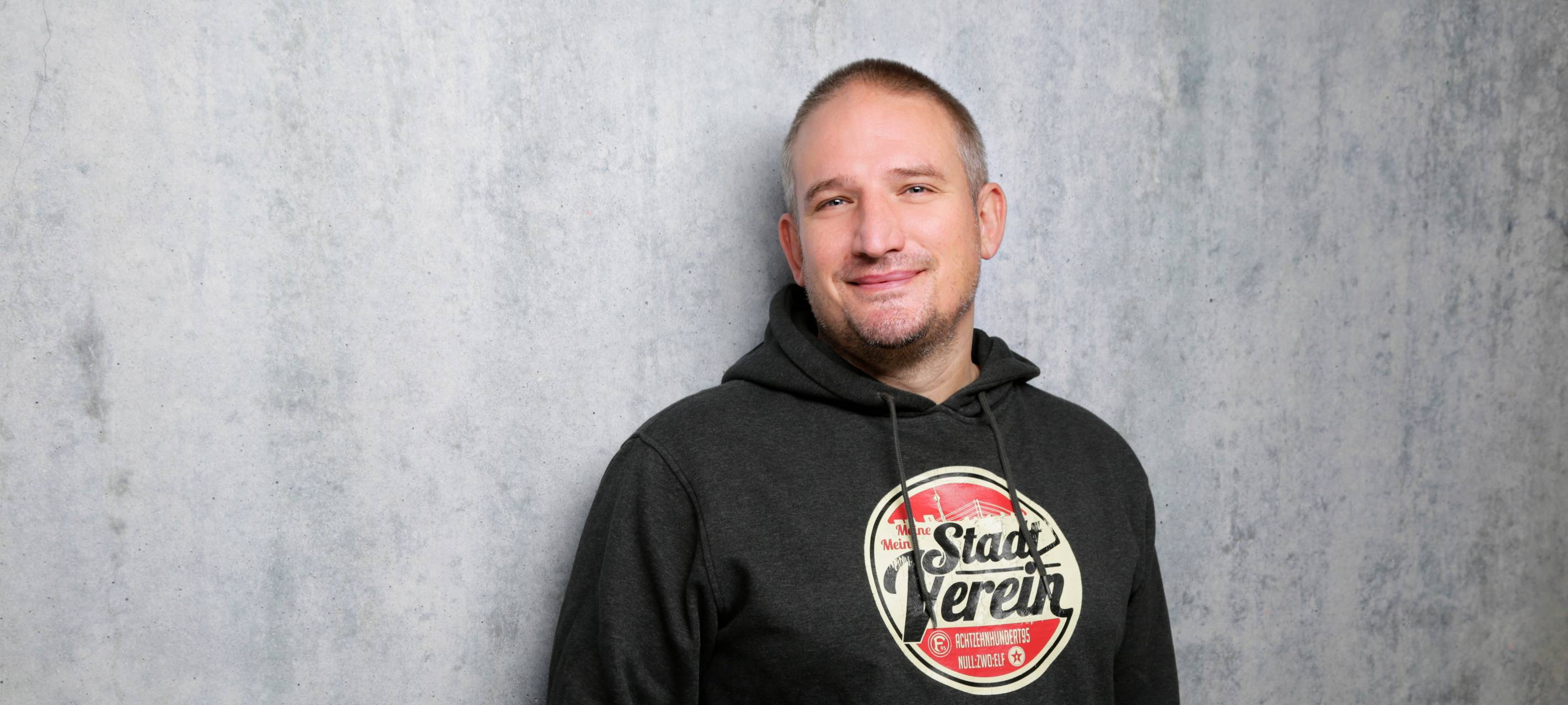 Fortuna-Reporter Olli Bendt vor einer grauen Wand