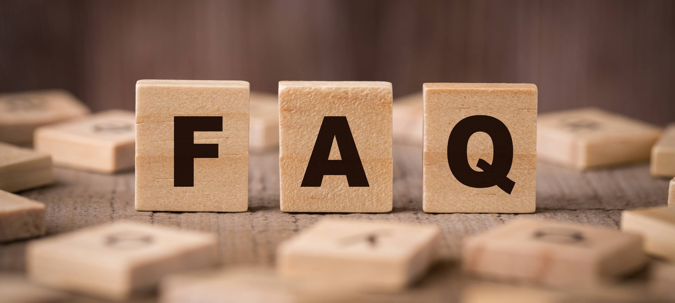 Ein FAQ-Schild in Form von hölzernen Bauklötzen.