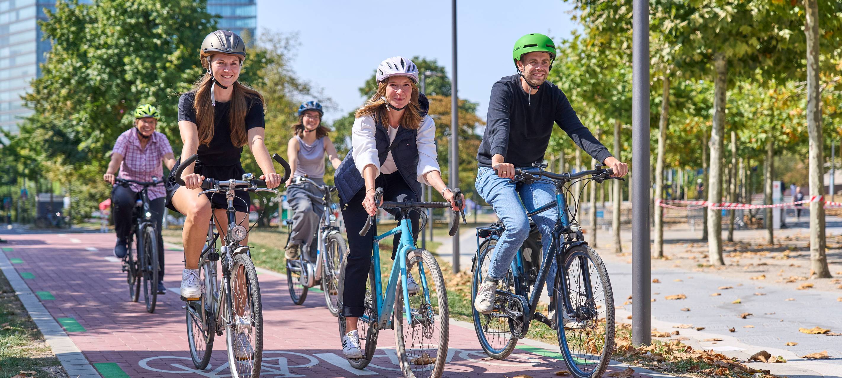 Aufruf zum Mitmachen beim Stadtradeln: Die Landeshauptstadt Düsseldorf beteiligt sich zum zwölften Mal hintereinander am Wettbewerb Stadtradeln des Klima-Bündnisses, dem größten kommunalen Netzwerk für Klimaschutz. Mehrere Fahrradfahrer radeln glücklich über einen Fahrradweg.