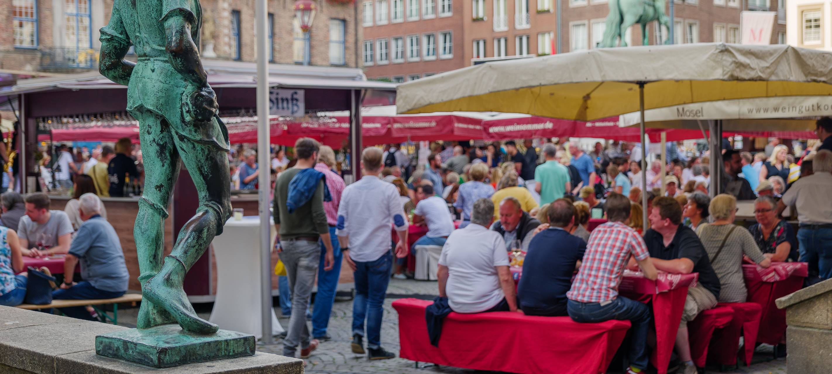 Menschenmengen genießen Outdoor-Aktivitäten und treffen sich auf einem Food-Festival rund um den Marktplatz in der Nähe des alten Rathauses in Düsseldorf, Deutschland.