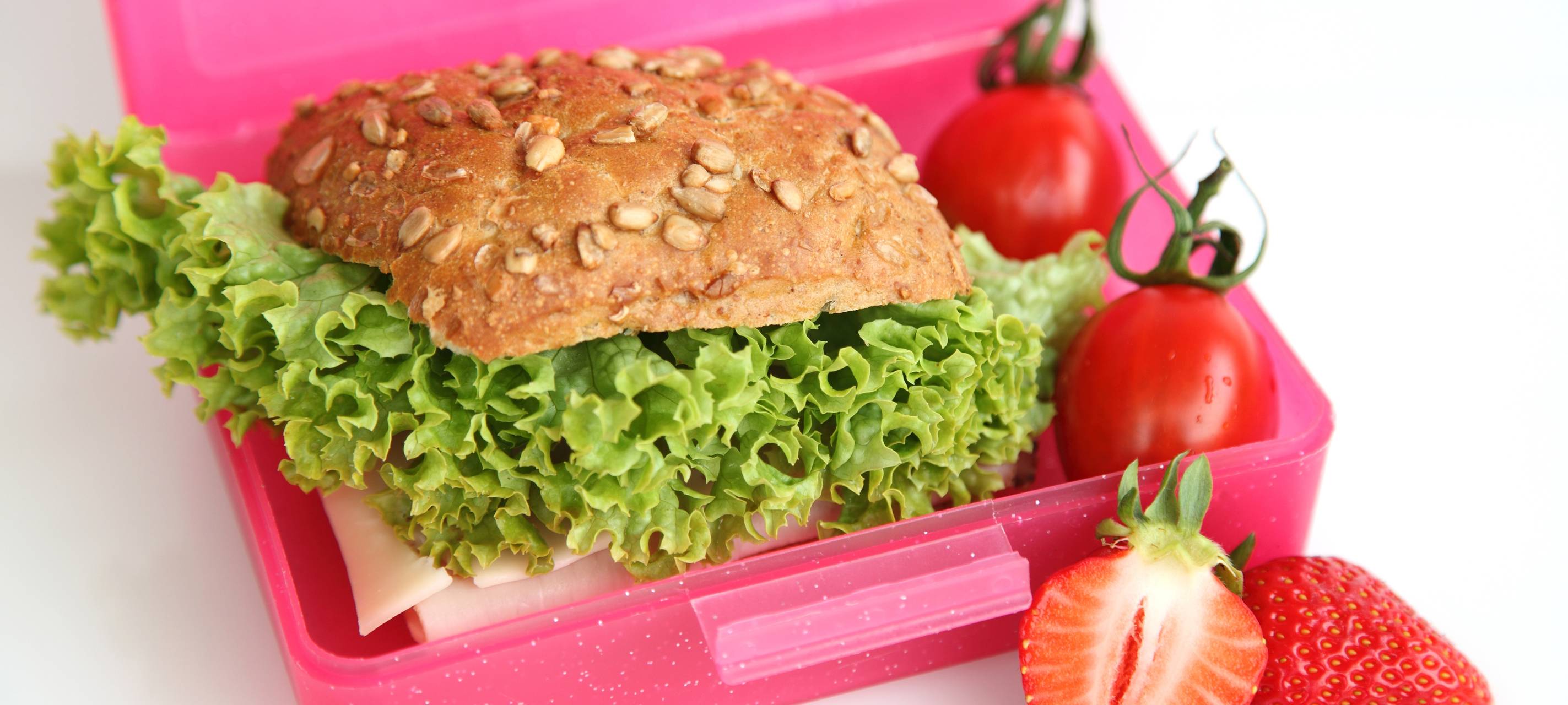 Schulfrühstück in einer Brotbox. Mit Obst, Brötchen und Gemüse.