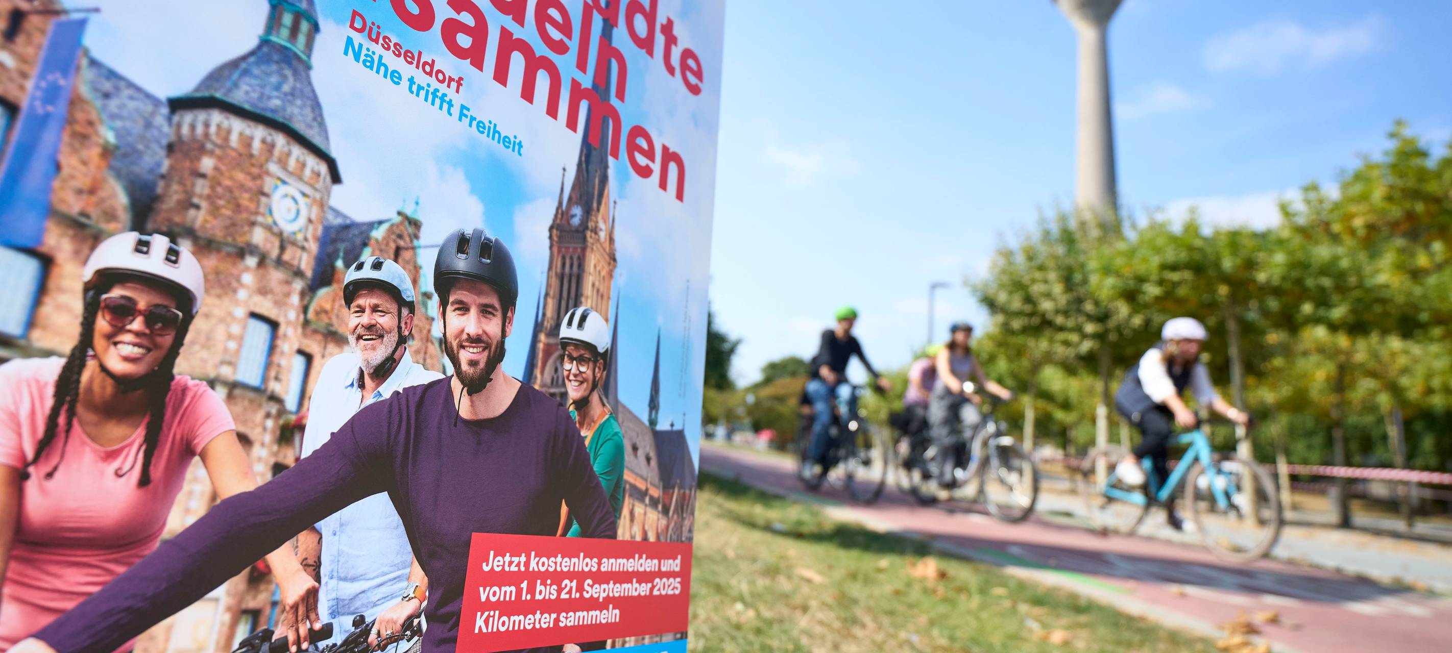 Ein Werbebanner weist auf den Wettbewerb Stadtradeln hin. Im Hintergrund der Rheinturm.