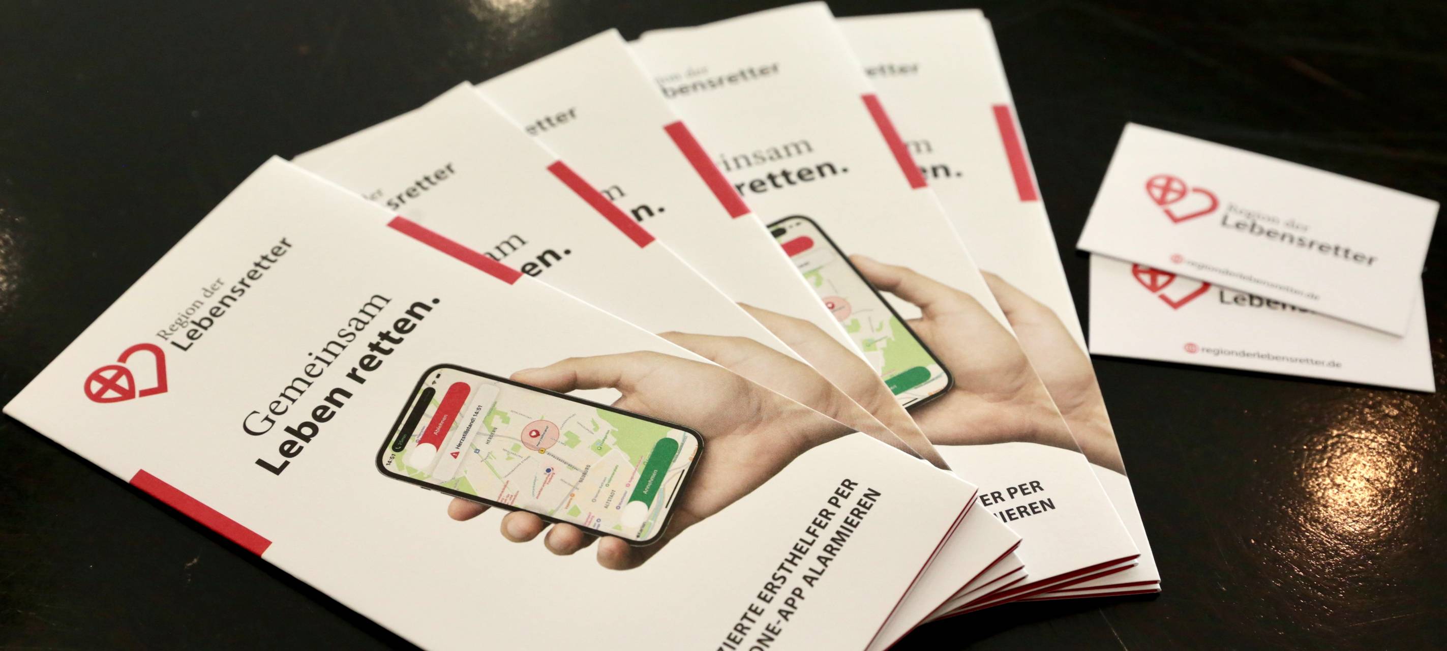 Flyer der App "Region der Lebensretter" aufgefächert