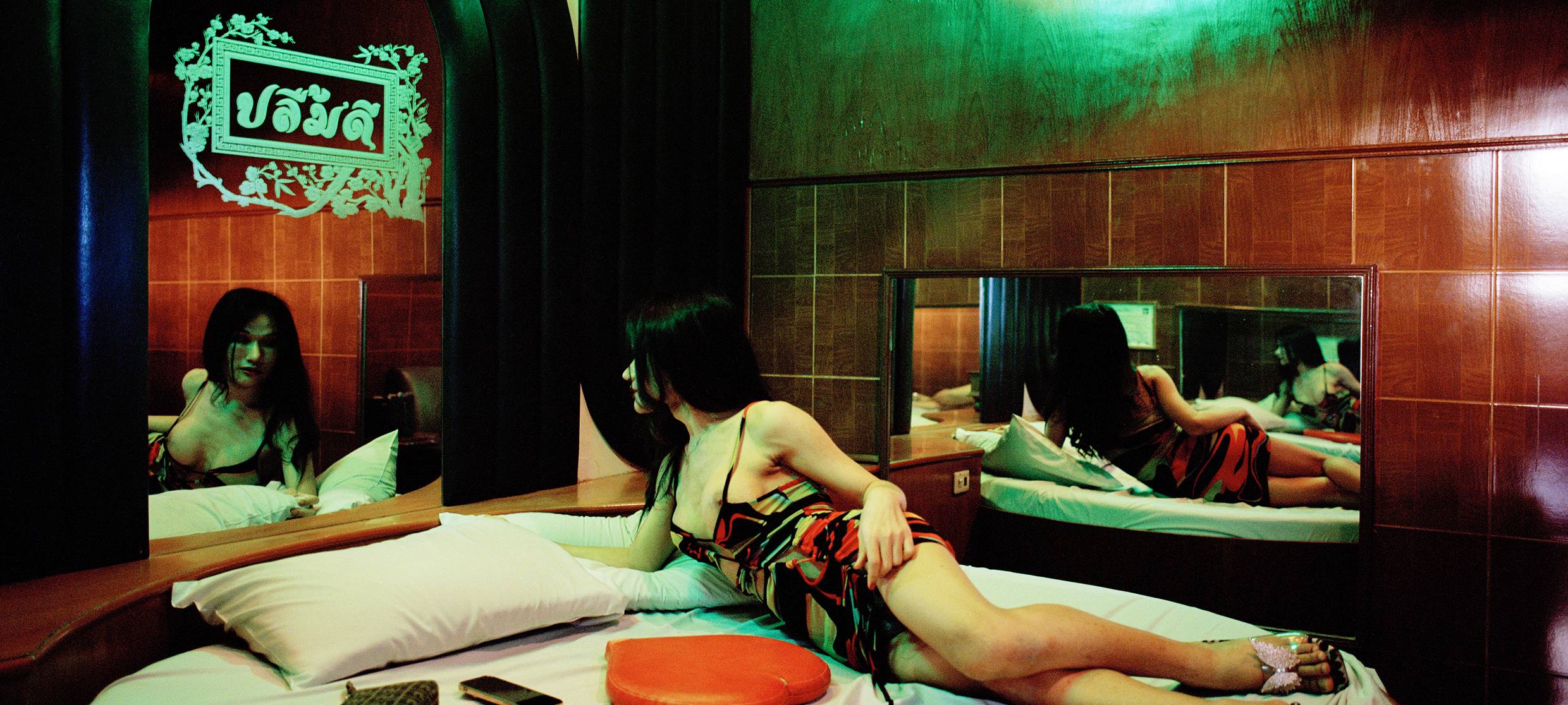 Eine Frau liegt lasziv auf einem Bett.