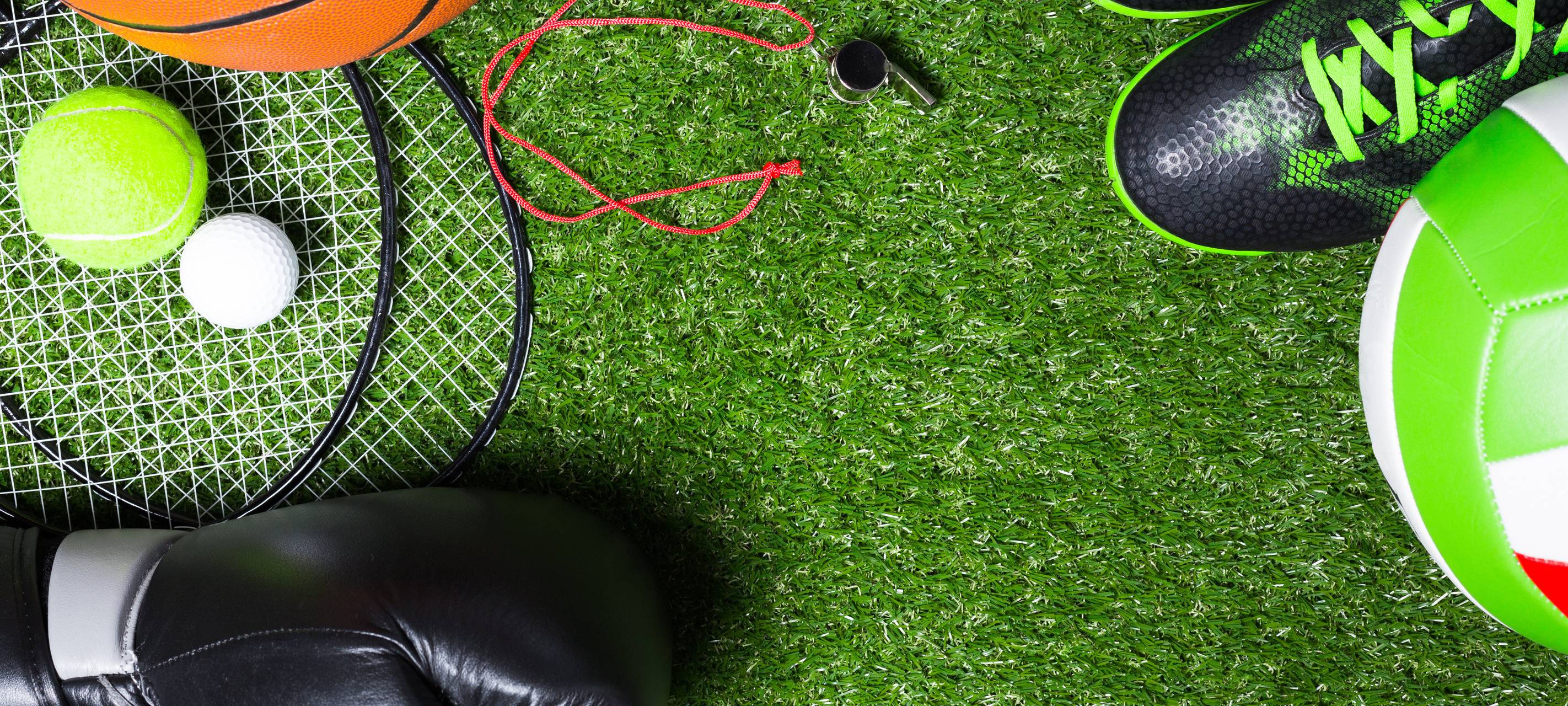 Verschiedene Sportgeräte auf Gras.