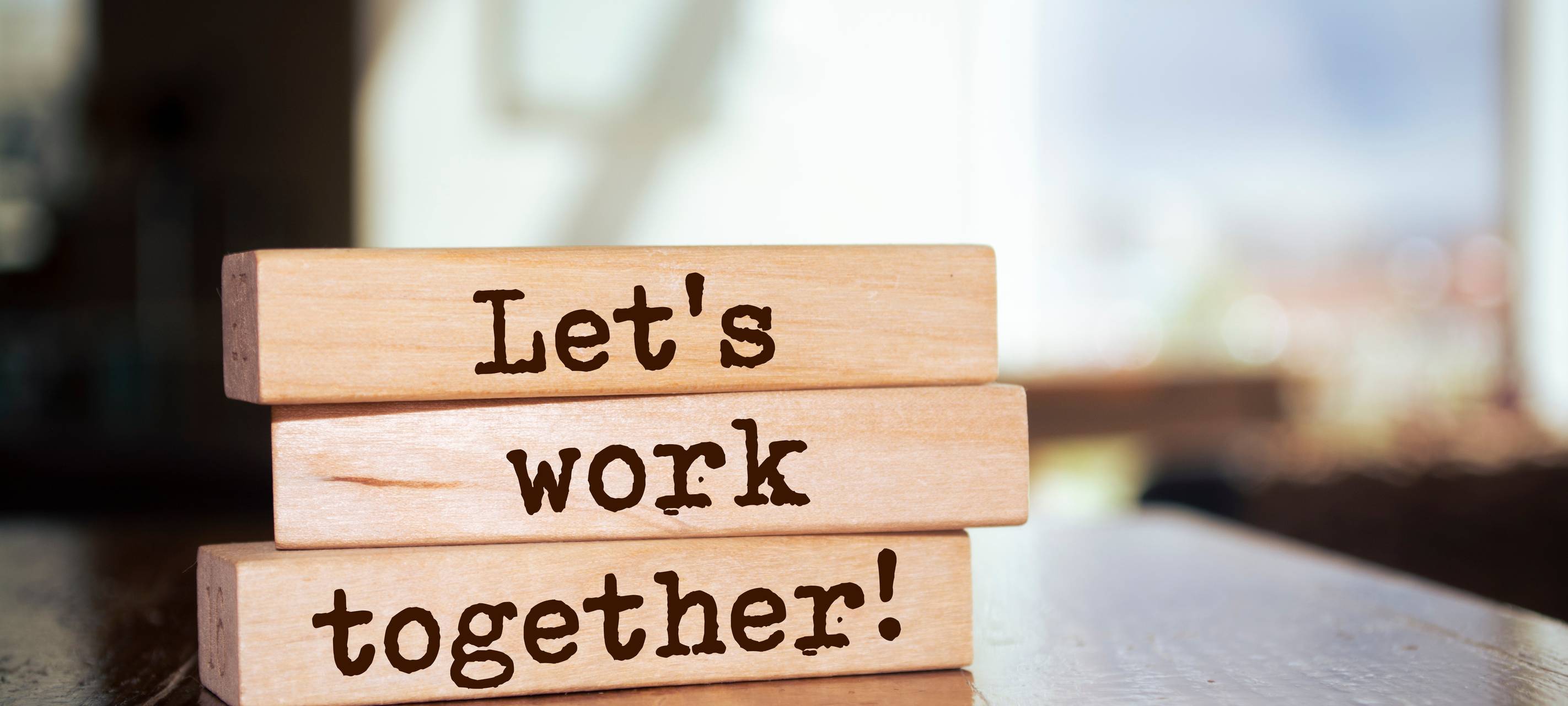Holzklötze mit der Aufschrift 'Let's work together'.