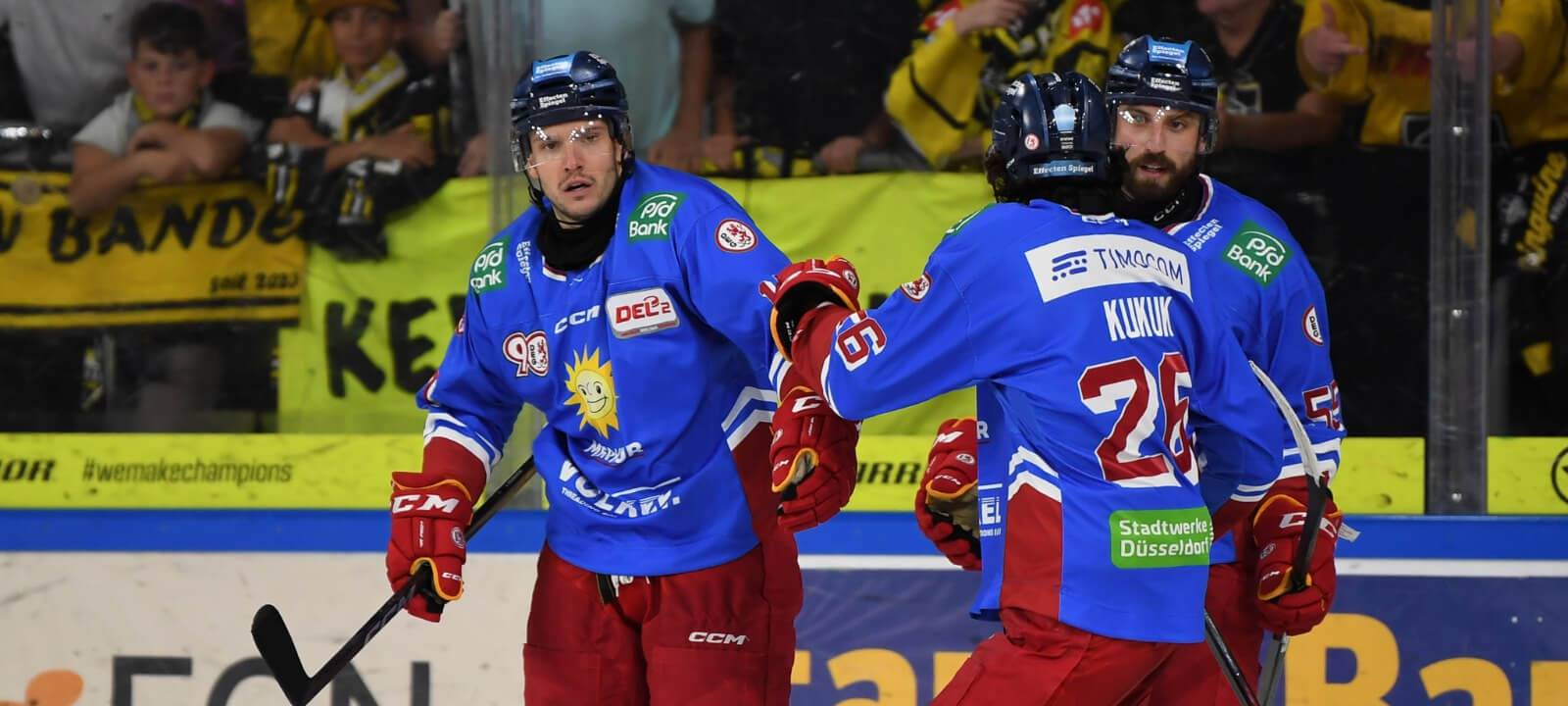 DEG-Spieler in blauen Auswärtstrikots bejubeln ein Tor beim Spiel bei den Krefelder Pinguinen.