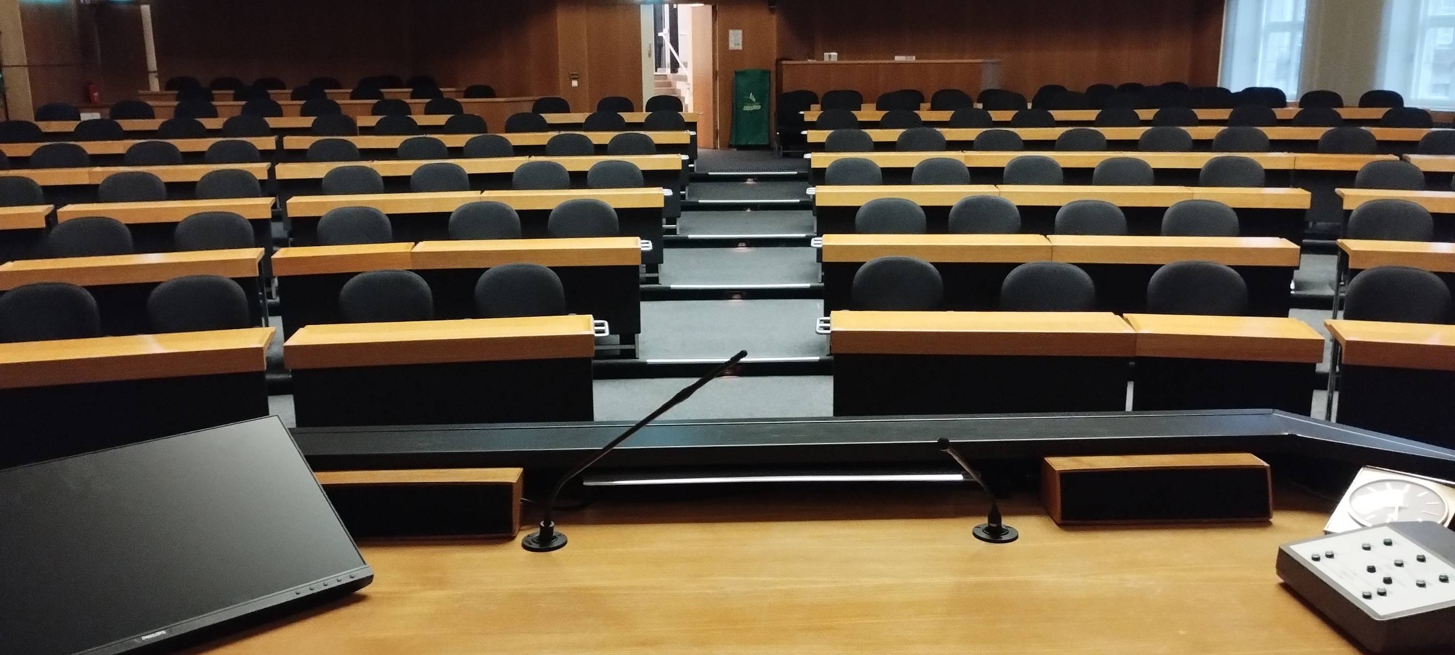 Blick in den leeren Ratssaal im Düsseldorfer Rathaus. Auf dem Tisch des OB stehen Laptop, Mikrofon und eine alte Uhr.