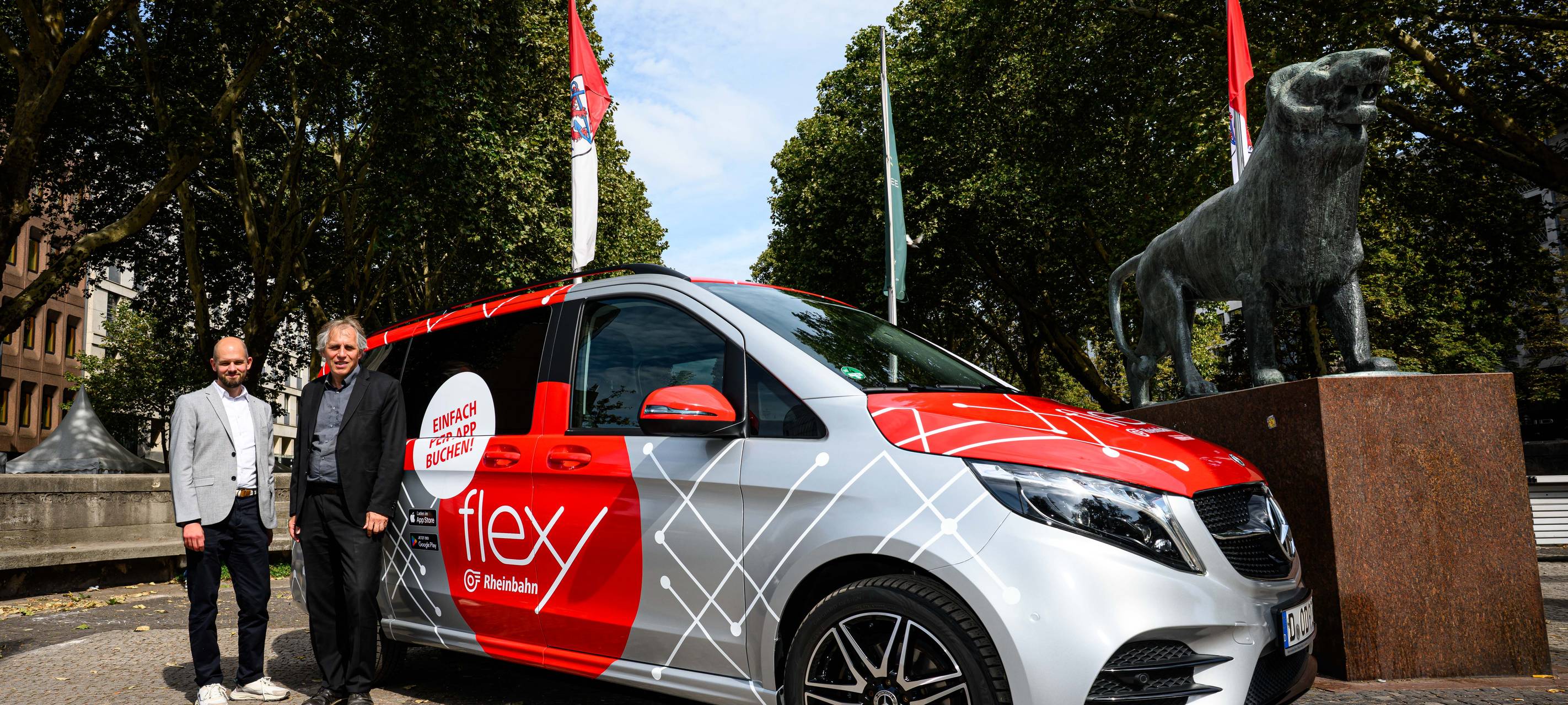 Christian Finke, Bereichsleiter Betrieb der Rheinbahn und Mobilitäts- und Umweltdezernent Jochen Kral stehen vor einem grauen Flexy-Fahrzeug.
