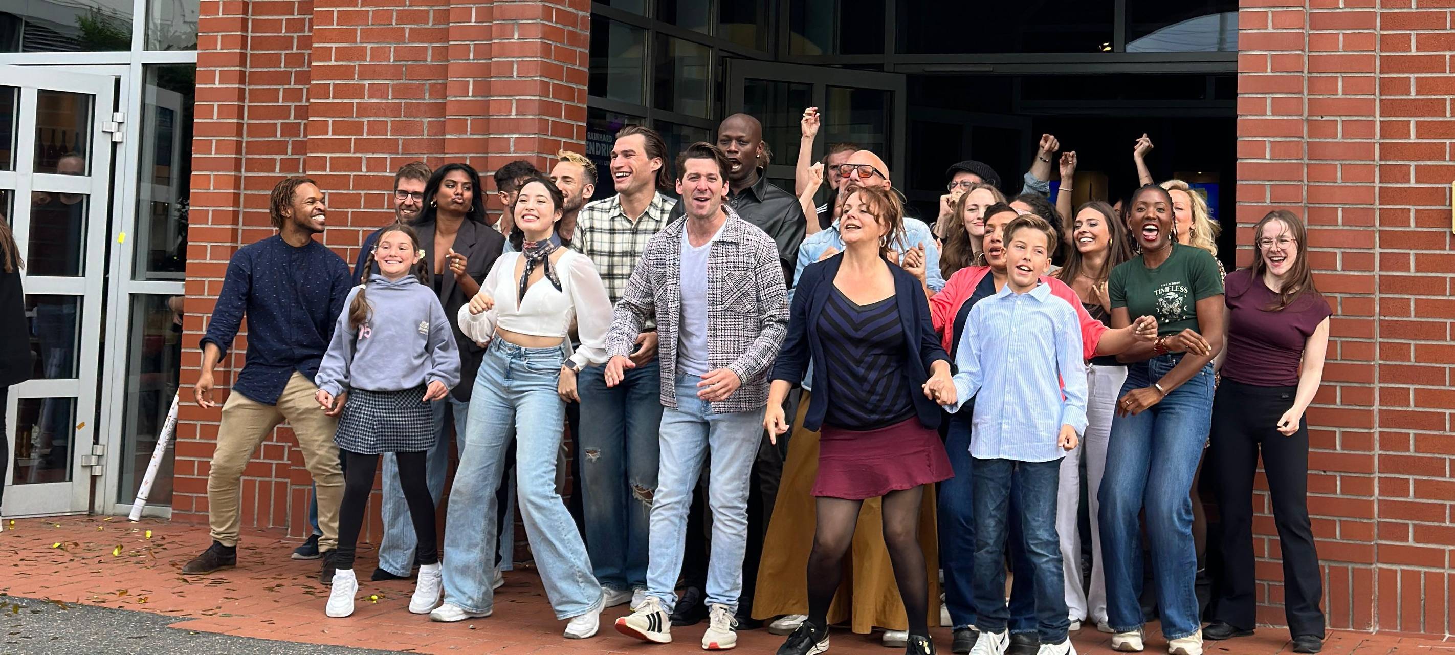 Die Darstellerinnen und Darsteller des Musicals "Mrs. Doubtfire" stehen vor dem Capitol Theater. Es ist der offizielle Probenstart für die Deutschlandpremiere.