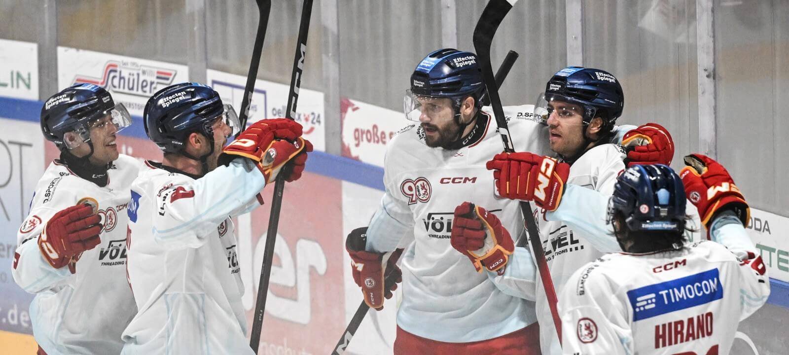 Fünf DEG-Spieler in weißen Trikots jubeln auf dem Eis über ein Tor beim Ausswärtssieg in Freiburg.