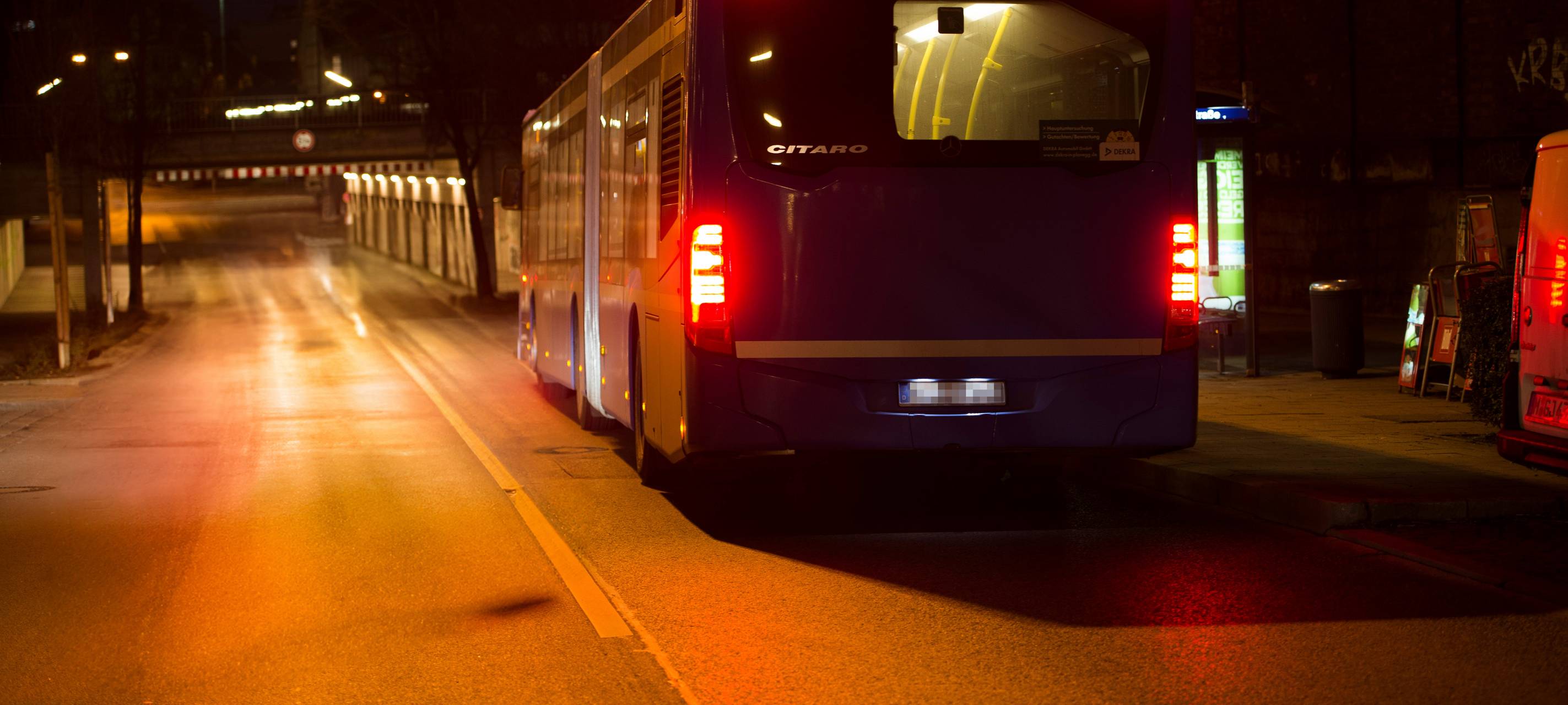 Ein Bus fährt nachts auf eine Unterführung zu