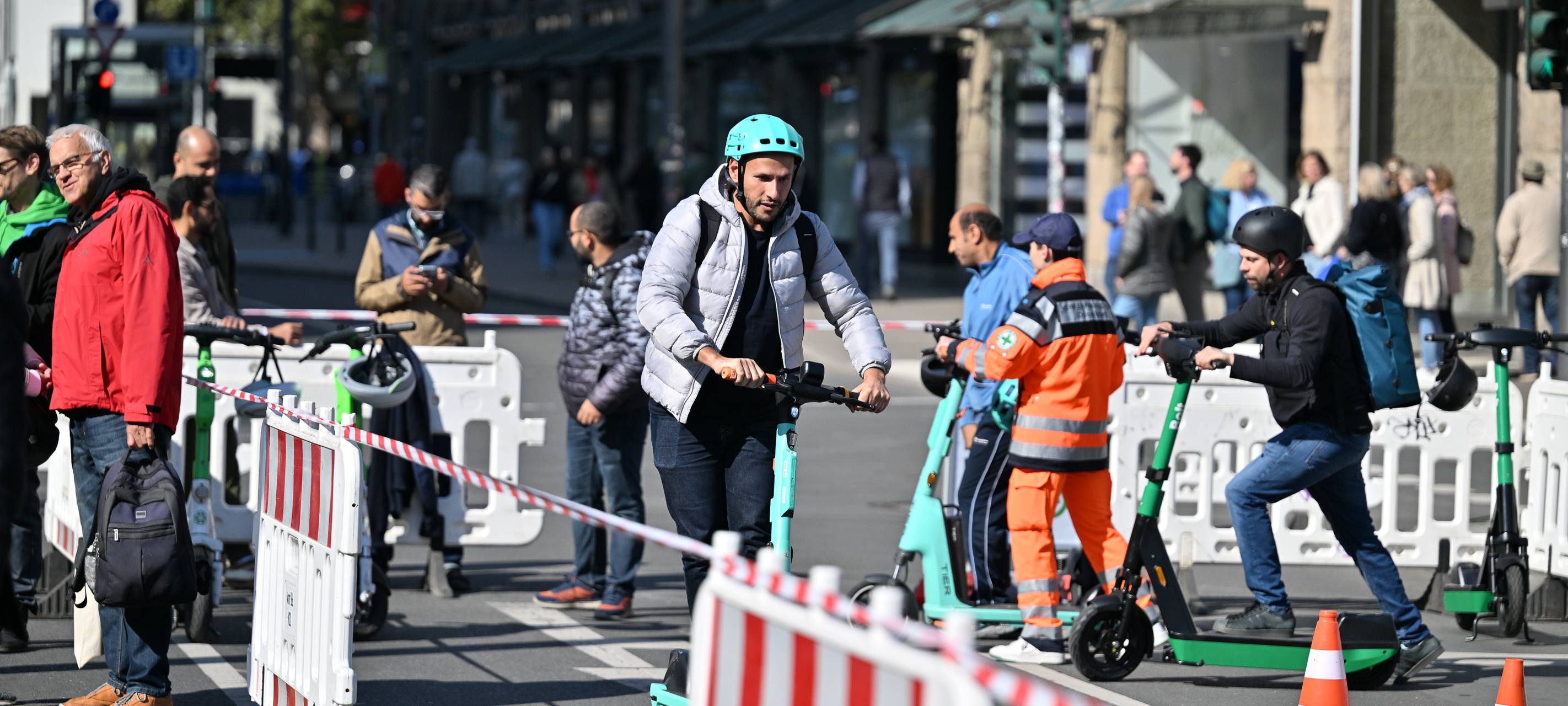 Mehrere Menschen nehmen an einem Sicherheitsparcours für E-Scooter teil.