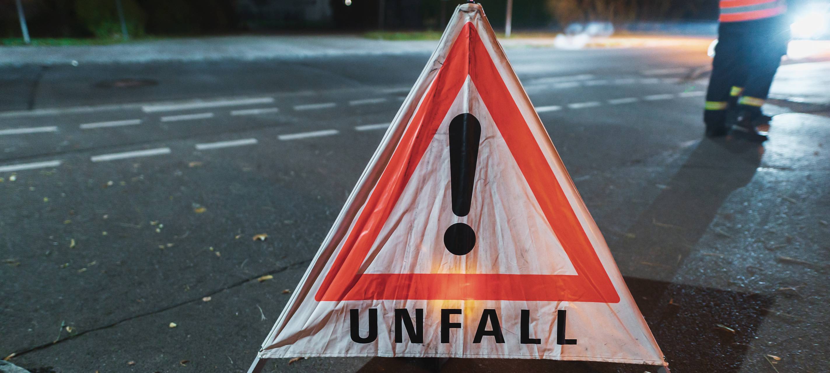 Warndreieck mit der Aufschrift Unfall bei einem nächtlichen Einsatz.