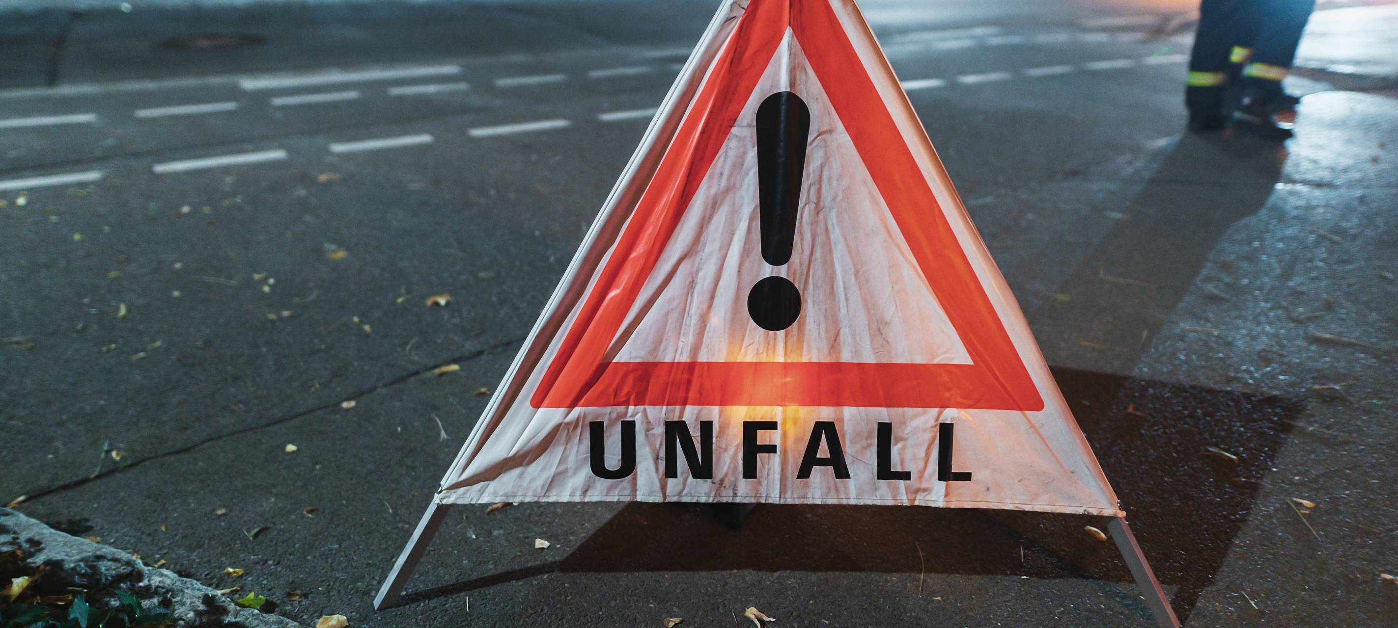 Warndreieck mit der Aufschrift Unfall bei einem nächtlichen Einsatz.