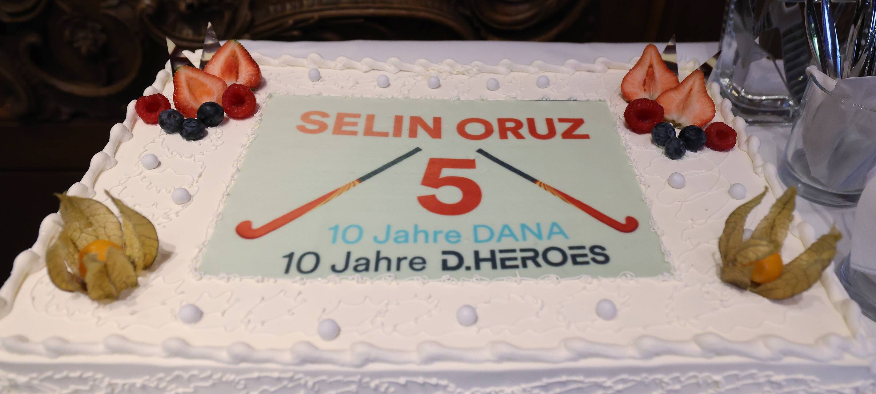 Große Torte für die Düsseldorfer Hockeyspielerin Selin Oruz. Darauf sind auch ihre Nummer 5 und zwei Hockeyschläger zu sehen. Außerdem ist die Torte an den Ecken mit Früchten garniert.