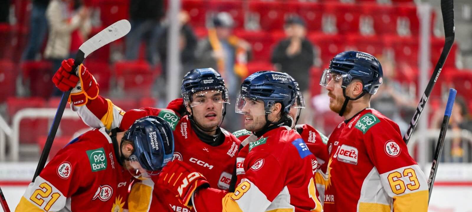 Vier DEG-Spieler haben sich in den Armen und bejubeln ein Tor auf dem Eis.