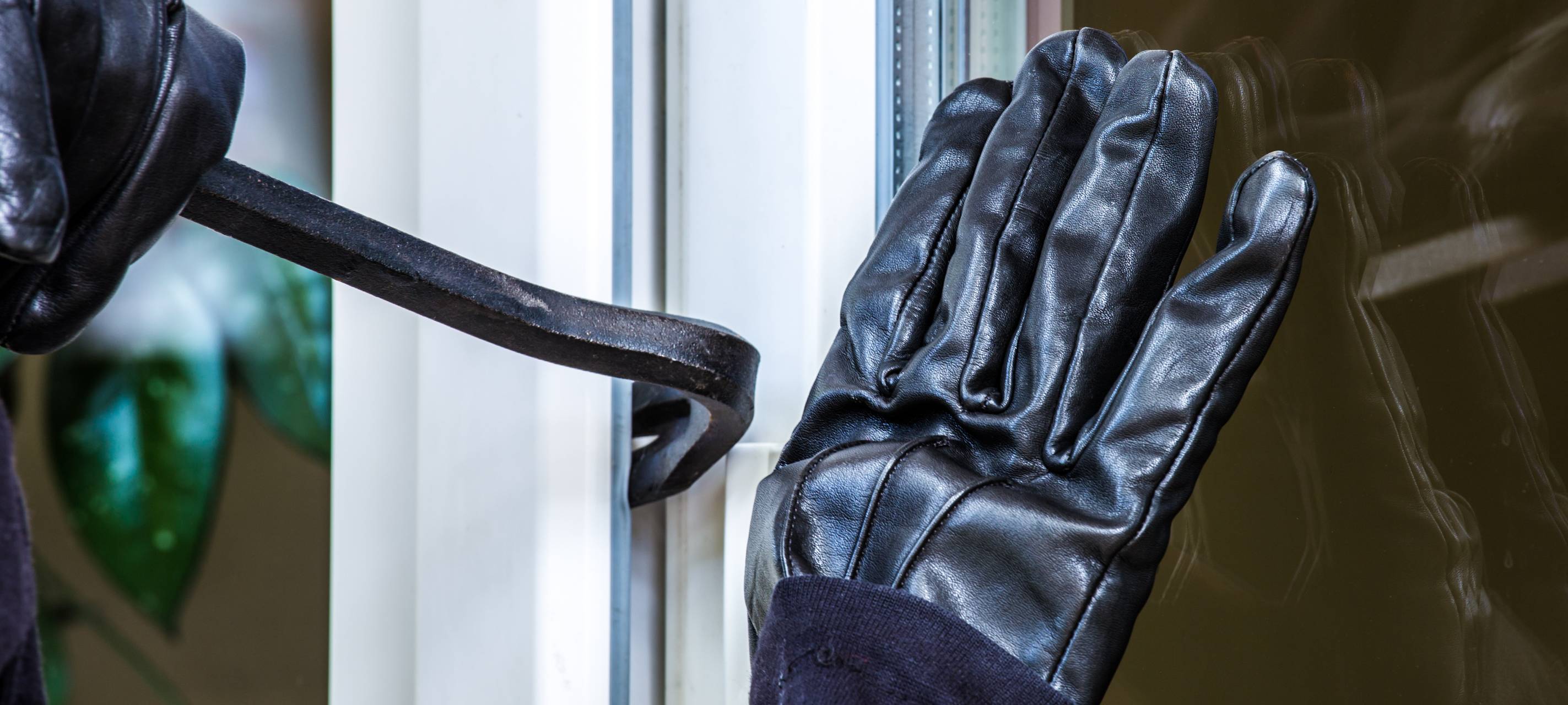 Ein unbekannter Einbrecher hebelt eine Terrassentür auf.