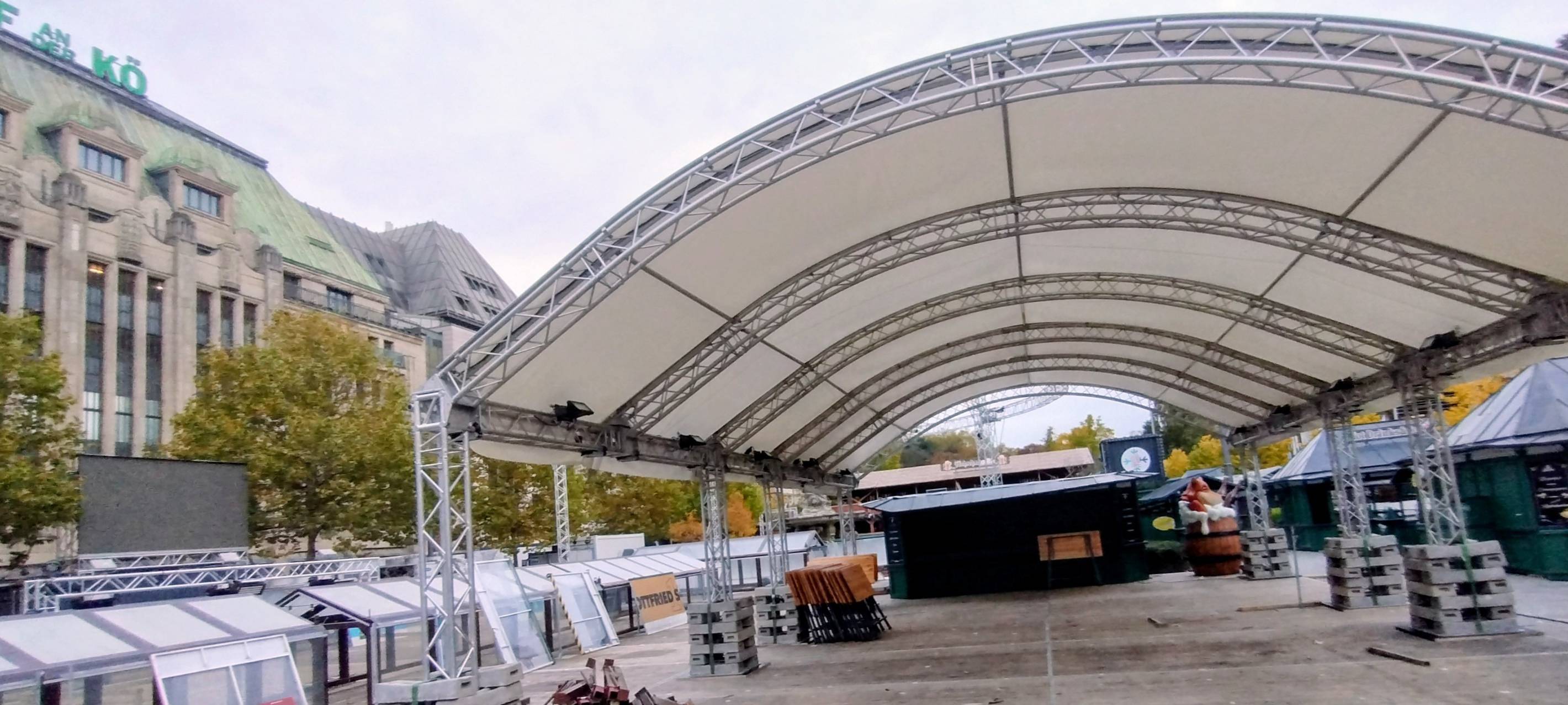 Aufbau der Eisbahn am Corneliusplatz auf der Kö. Neben dem Kaufhof erkennen wir unter anderem den Boden der späteren Eisbahn und das Zeltdach.