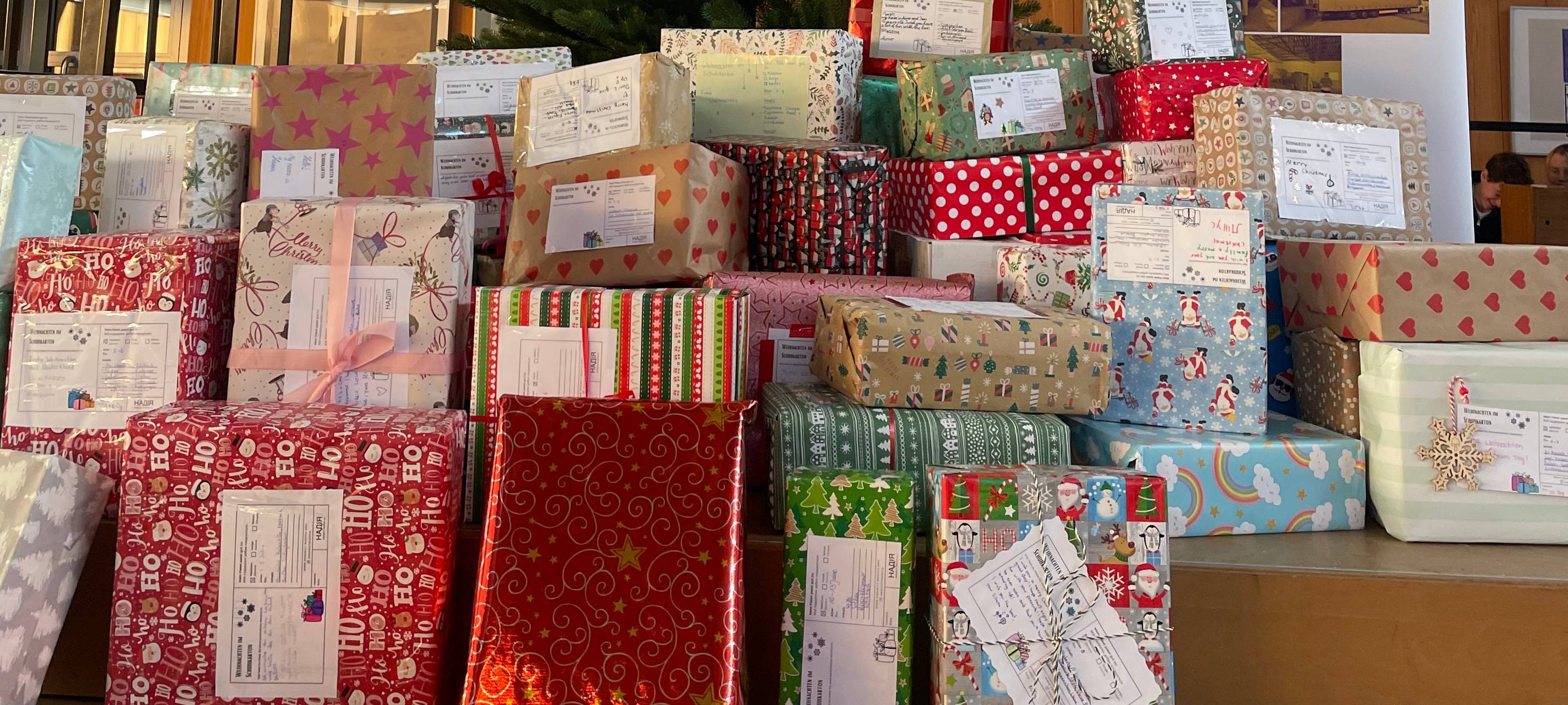 Geschenke für das Project Nadiya vor dem Weihnachtsbaum in der Marie-Curie-Schule