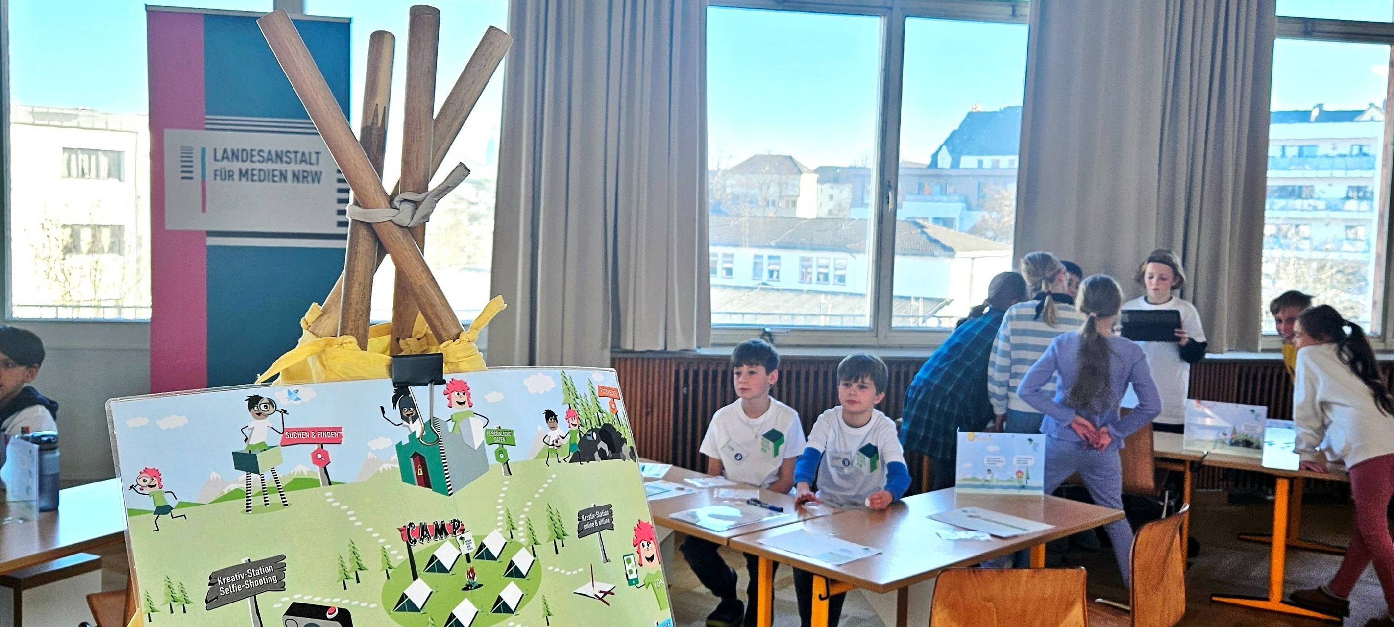 Kinder nehmen in der Aula der Bonifatius Grundschule am Programm der Medienscouts teil.