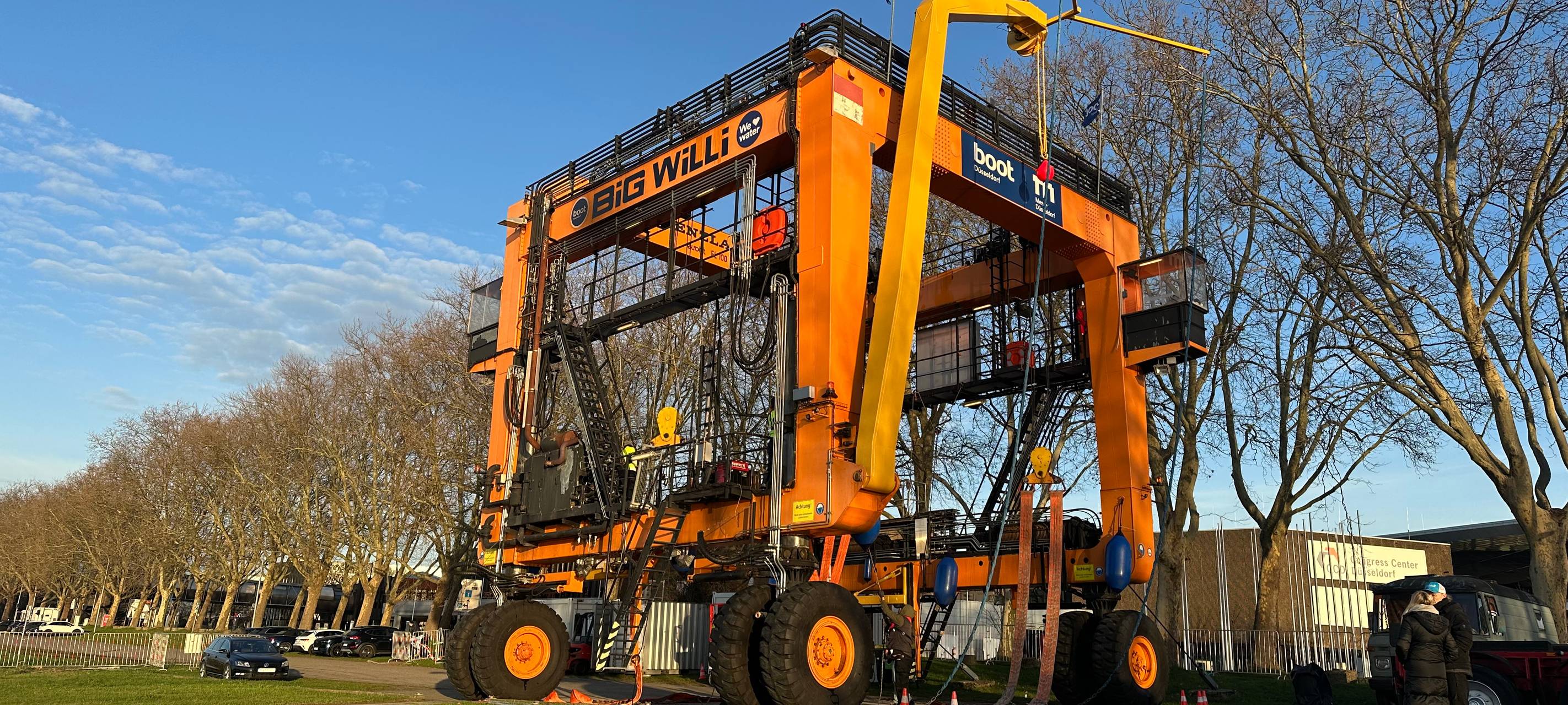 Der Messekran Big Will hat eine Yacht für die Messe boot aus dem Rhein gehoben.