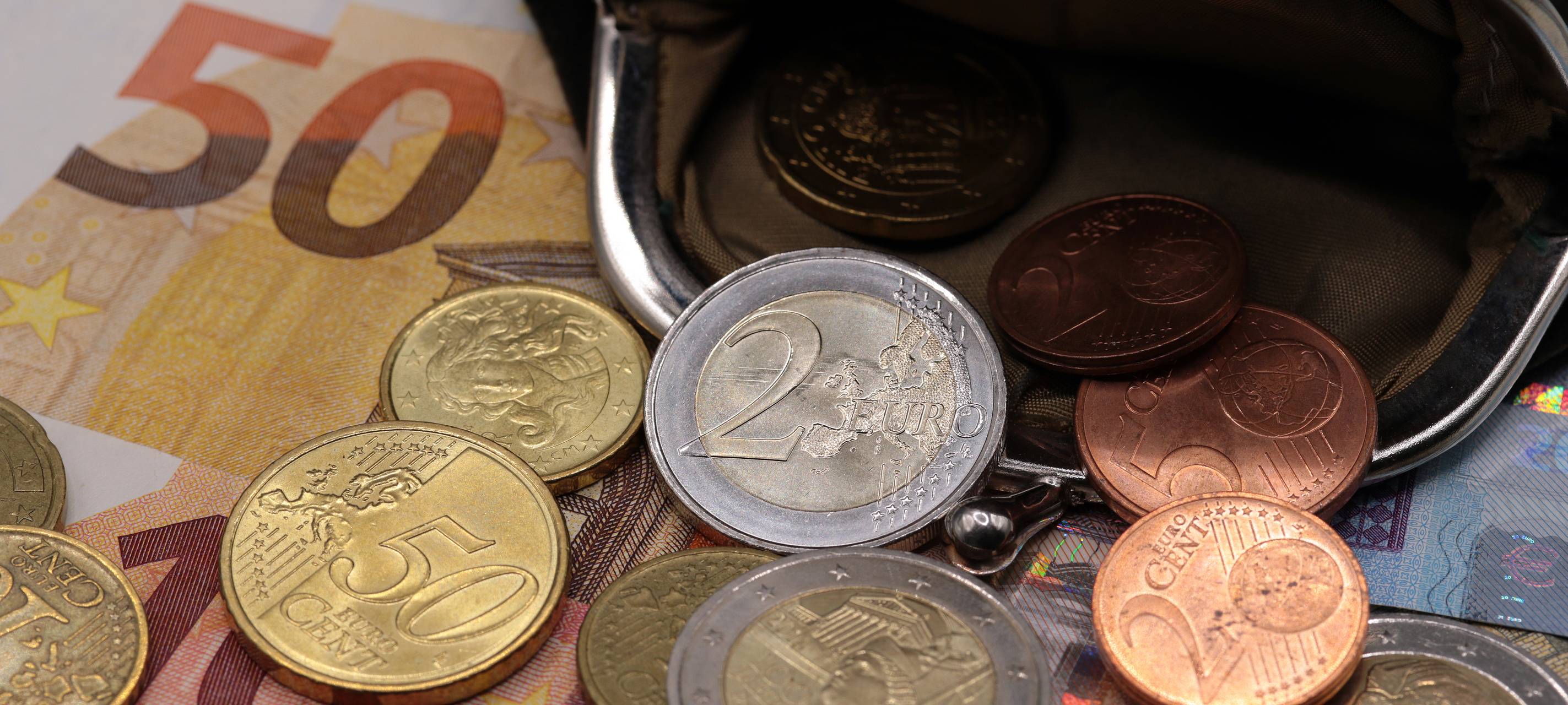 Euro-Münzen- und Scheine und eine Geldbörse.