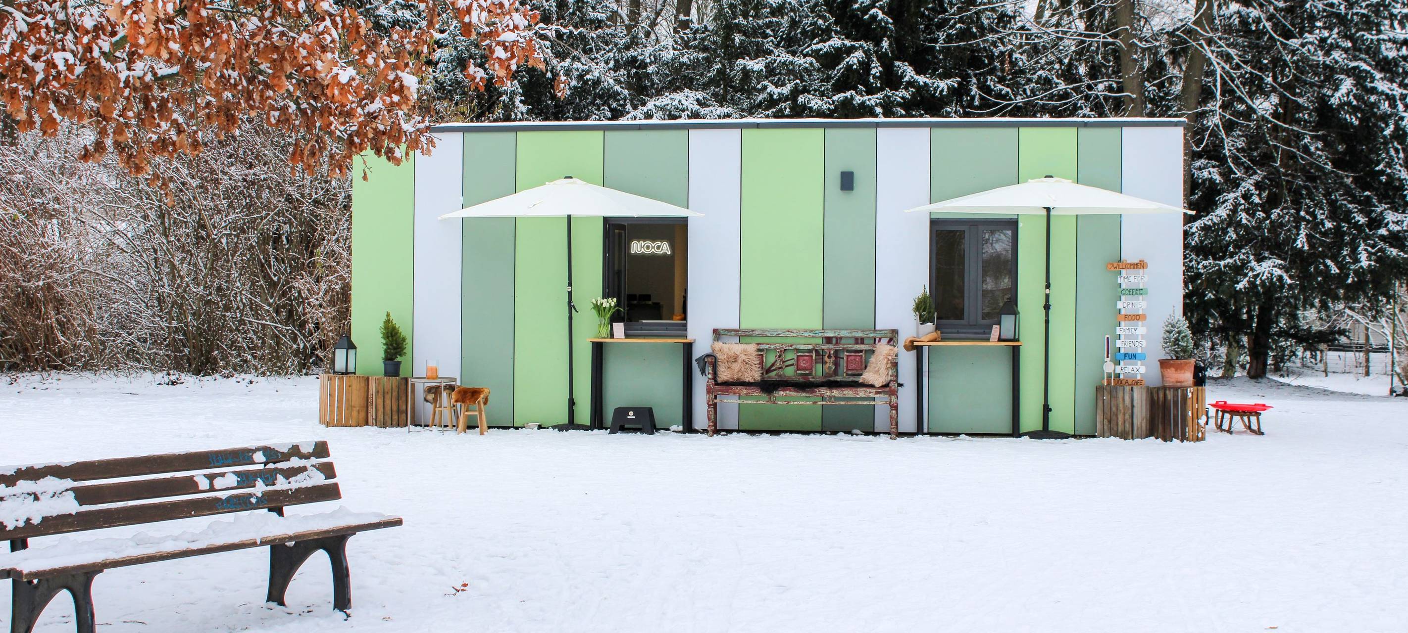 Eine kleine grüne Hütte im Schneebedeckten Park - die NOCA-BAR