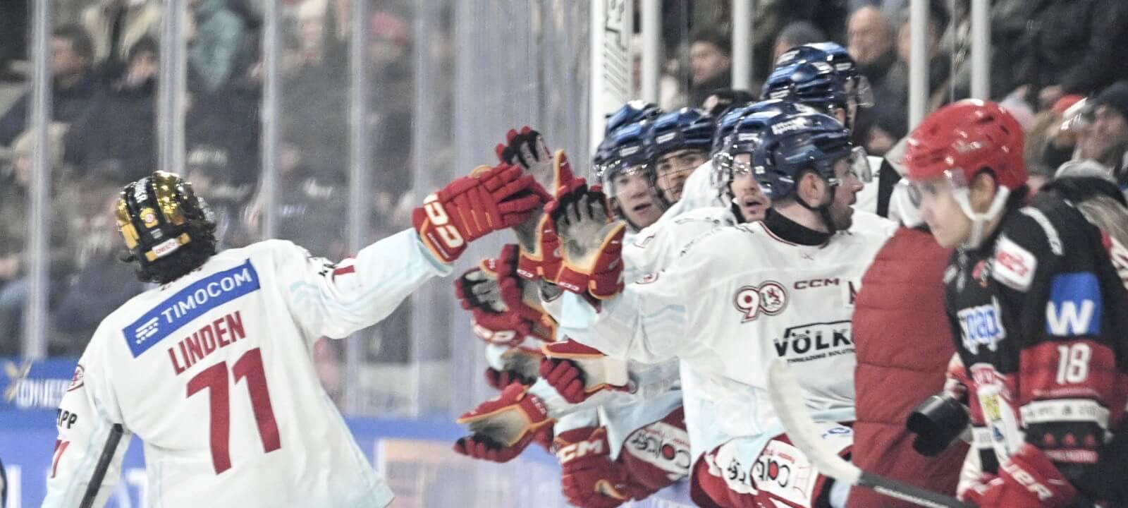 DEG-Stürmer Ture Linden klatscht an der Bande seine Mannschaftskollegen ab.