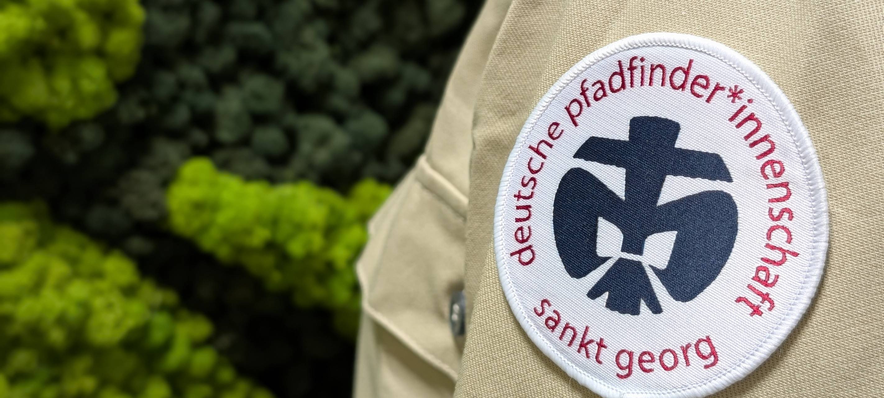 Die Schulter eines Pfadfinders mit dem Logo der Deutschen Pfadfinderschaft Sankt Georg.