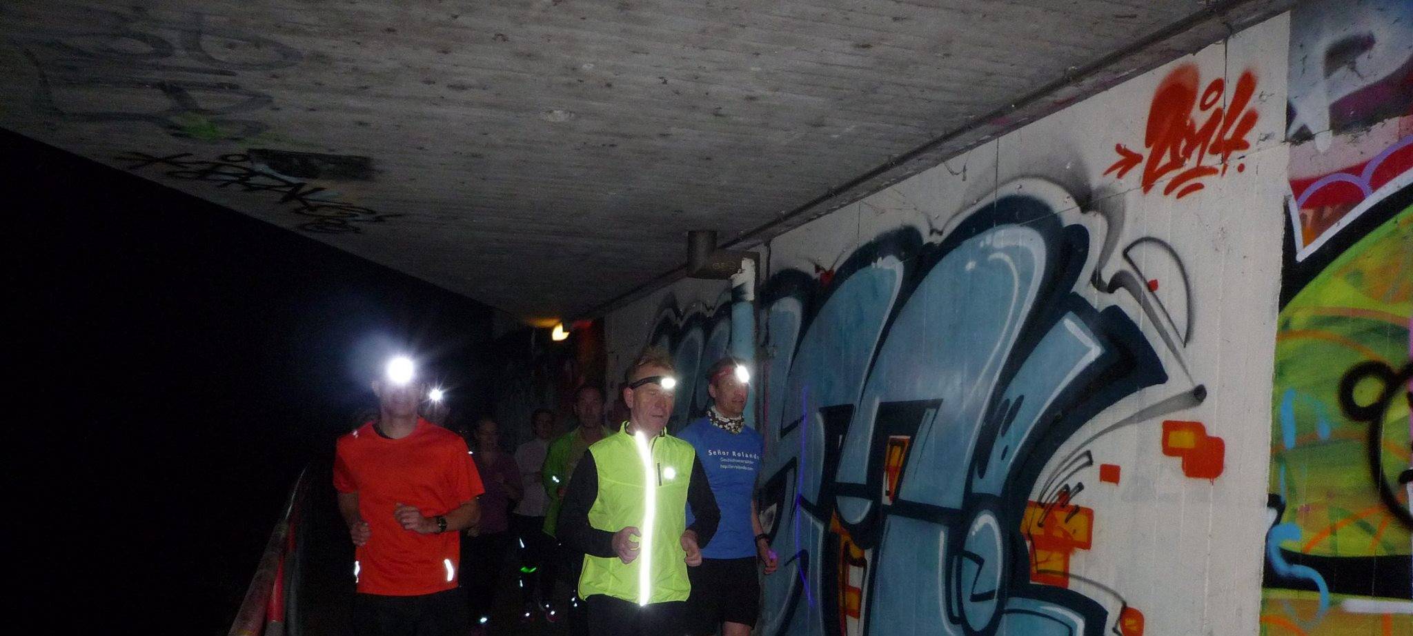 Läufer laufen nachts mit Stirnlampe durch Düsseldorf.