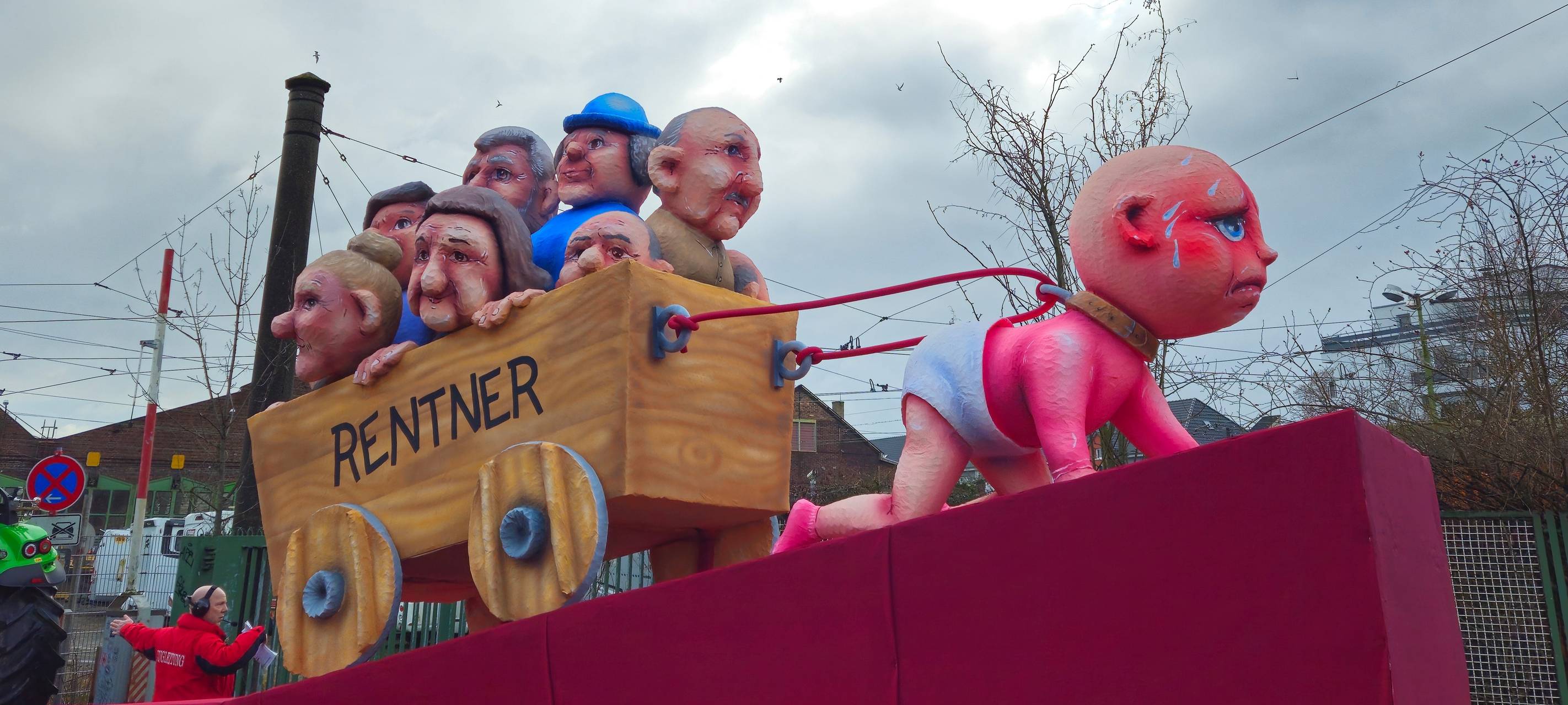 Mottowagen: Ein Baby zieht einen Bollerwagen voller Rentner