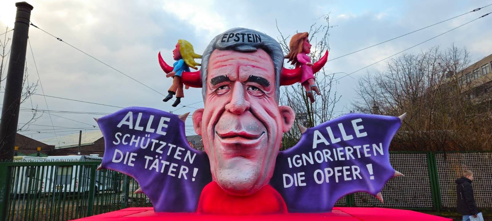 Eine Epstein-Figur hat zwei Frauen auf Hörnern aufgespießt. Dabei ist zu lesen, dass die Täter geschützt- und die Opfer ignoriert werden.