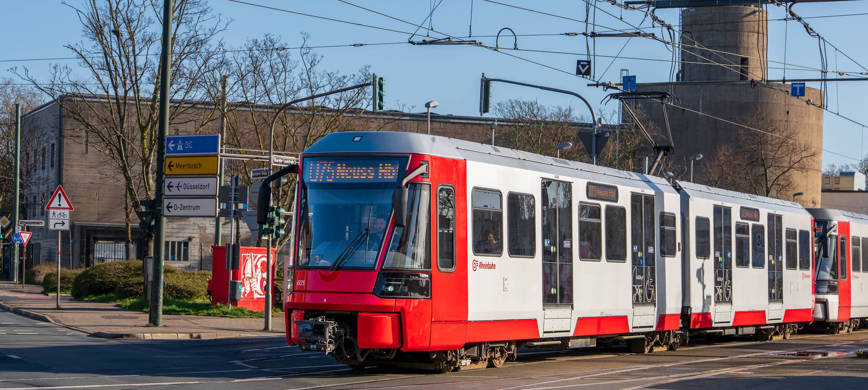 Am Handweiser in Heerdt fährt eine neue, rot lackierte Stadtbahn U75 der Rheinbahn.