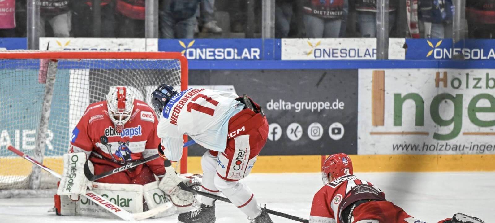 DEG-Stürmer Niederberger schießt aufs Tor, zwei Landshuter Spieler versuchen noch zu retten.