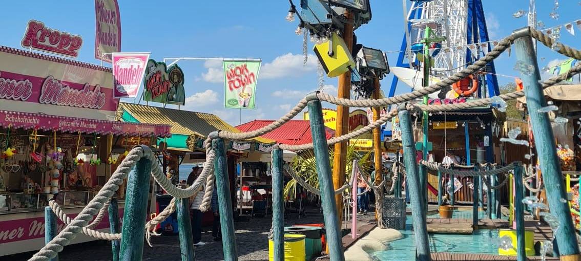 Verschiedene Buden und das Riesenrad auf der Frühlingskirmes am Tonhallenufer