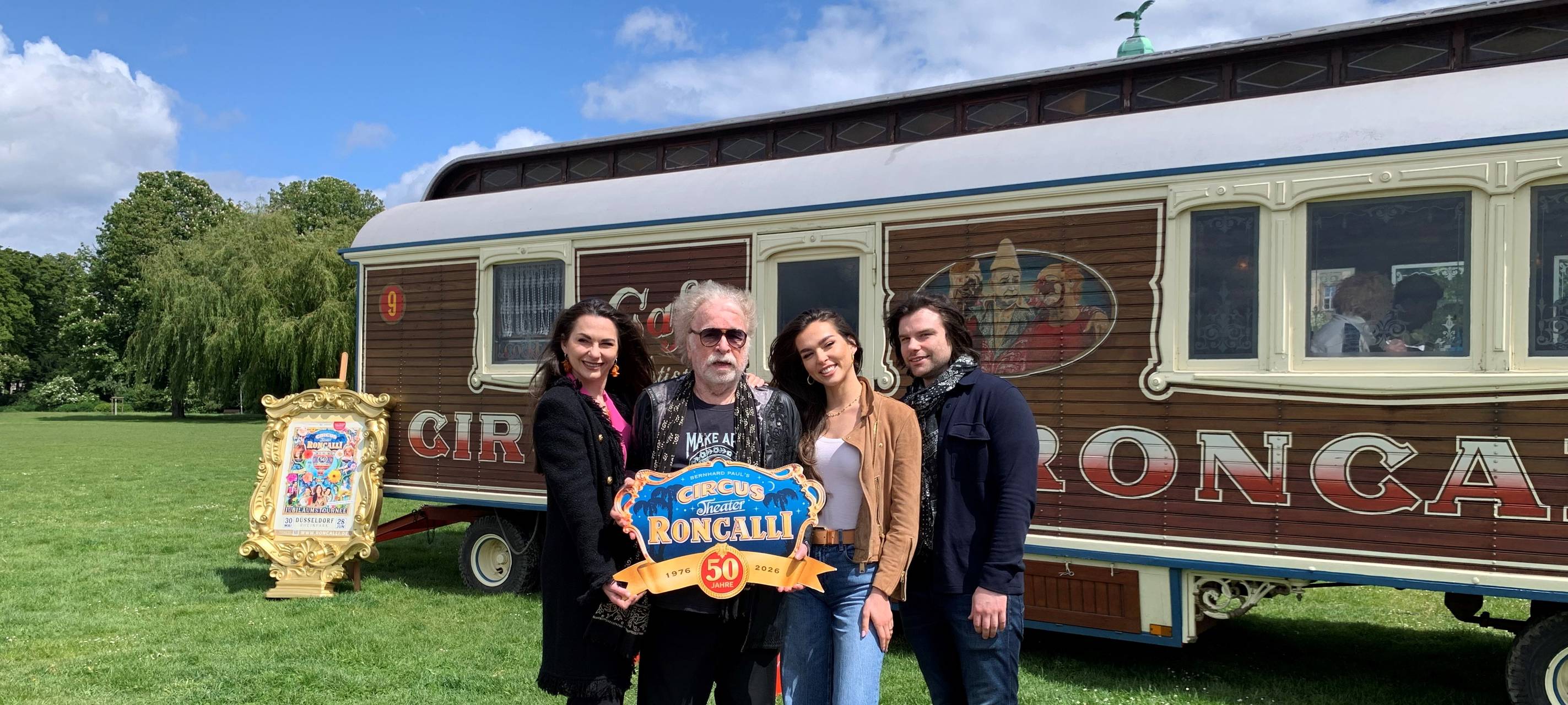 Apollo-Gründer Bernhard Paul und drei weitere Personen stehen vor einem Bauwagen des Circus.