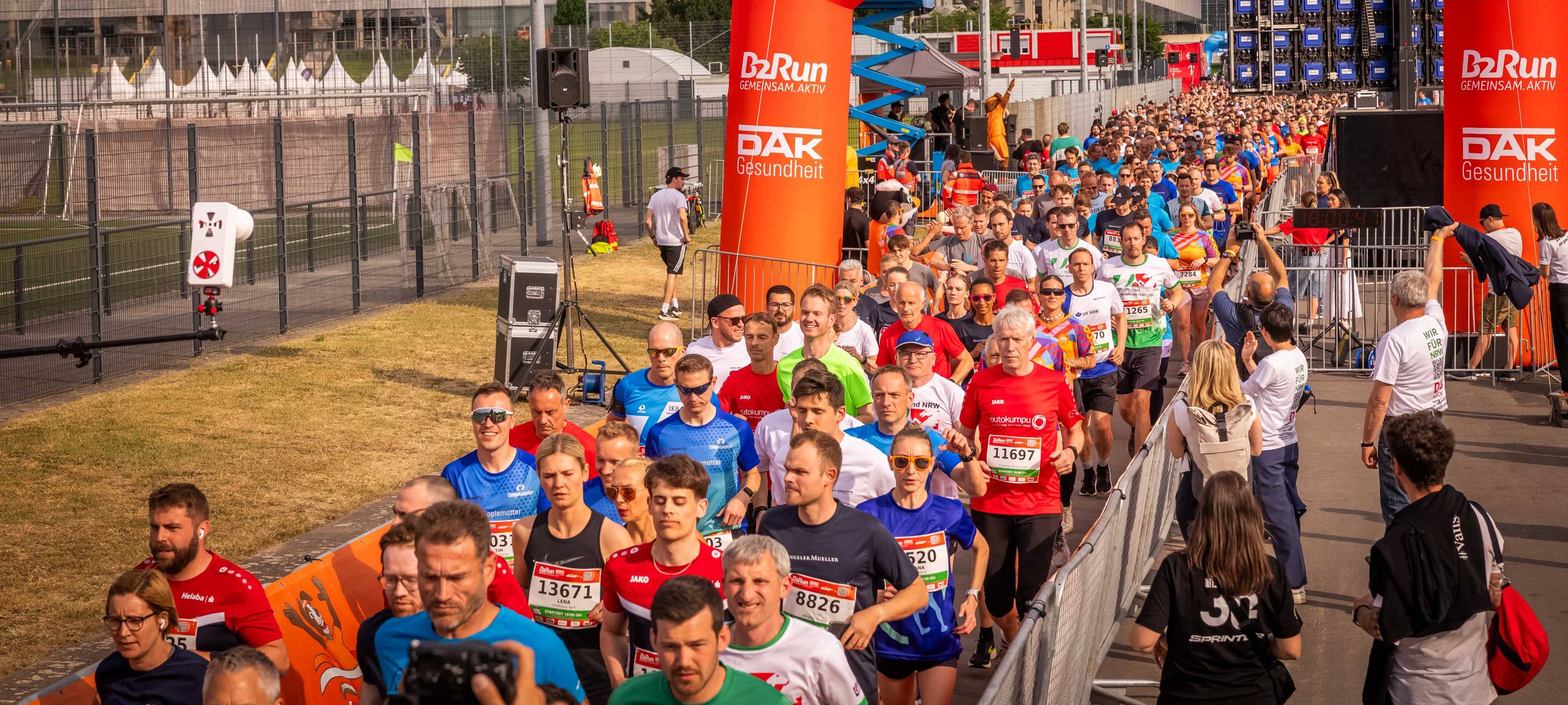 Tausende Läuferinnen und Läufer überqueren die Startlinie des B2Run an der Merkur-Spielarena in Düsseldorf.