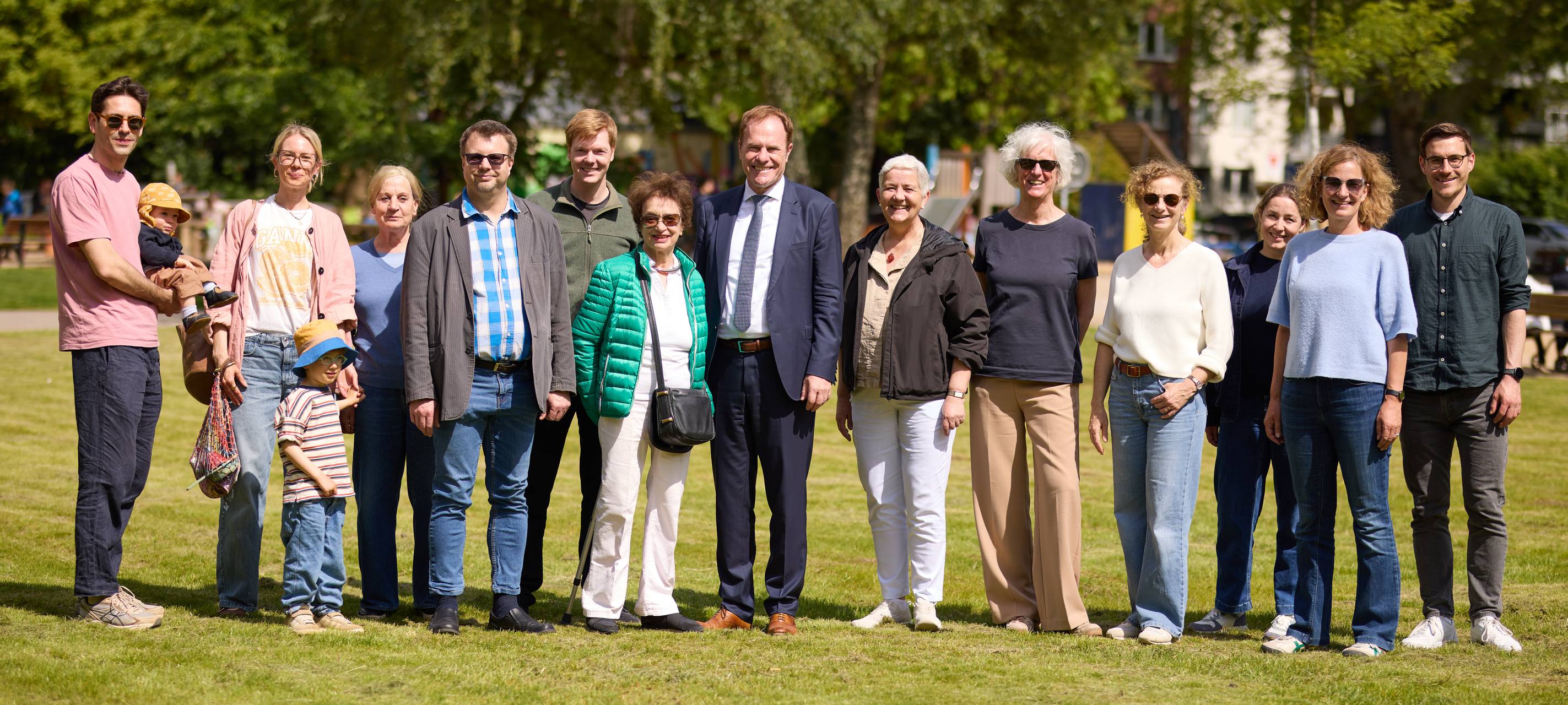 OB Keller und viele Mitarbeitende stehen auf dem Rasen des neu gestalteten Schillerplatzes in Düsseltal.