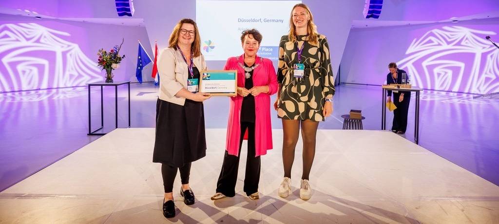 Bei der Preisverleihung der Eurocities Awards 2026 (v.l.): Jessica Breitkopf, Leiterin des Büros für Internationale und Europäische Angelegenheiten, Bürgermeisterin von Utrecht, Sharon Dijksma, und Clarissa Loch, stellvertretende Sachgebietsleitung Beratung und Hilfen für Obdachlose im Amt für Migration und Integration.