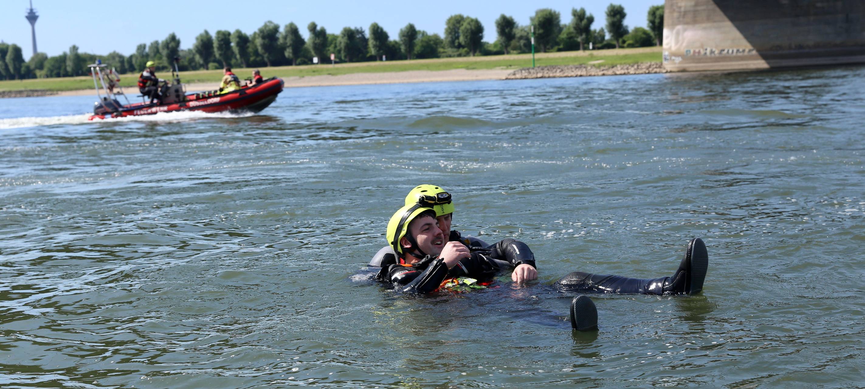 Die Düsseldorfer Feuerwehr übt die Rettung einer Person aus dem Rhein. Ein Helfer versucht, mit der Person an Land zu schwimmen.