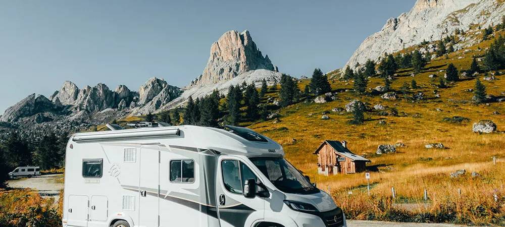 Ein Caravan steht auf einer Straße vor einem Berg.
