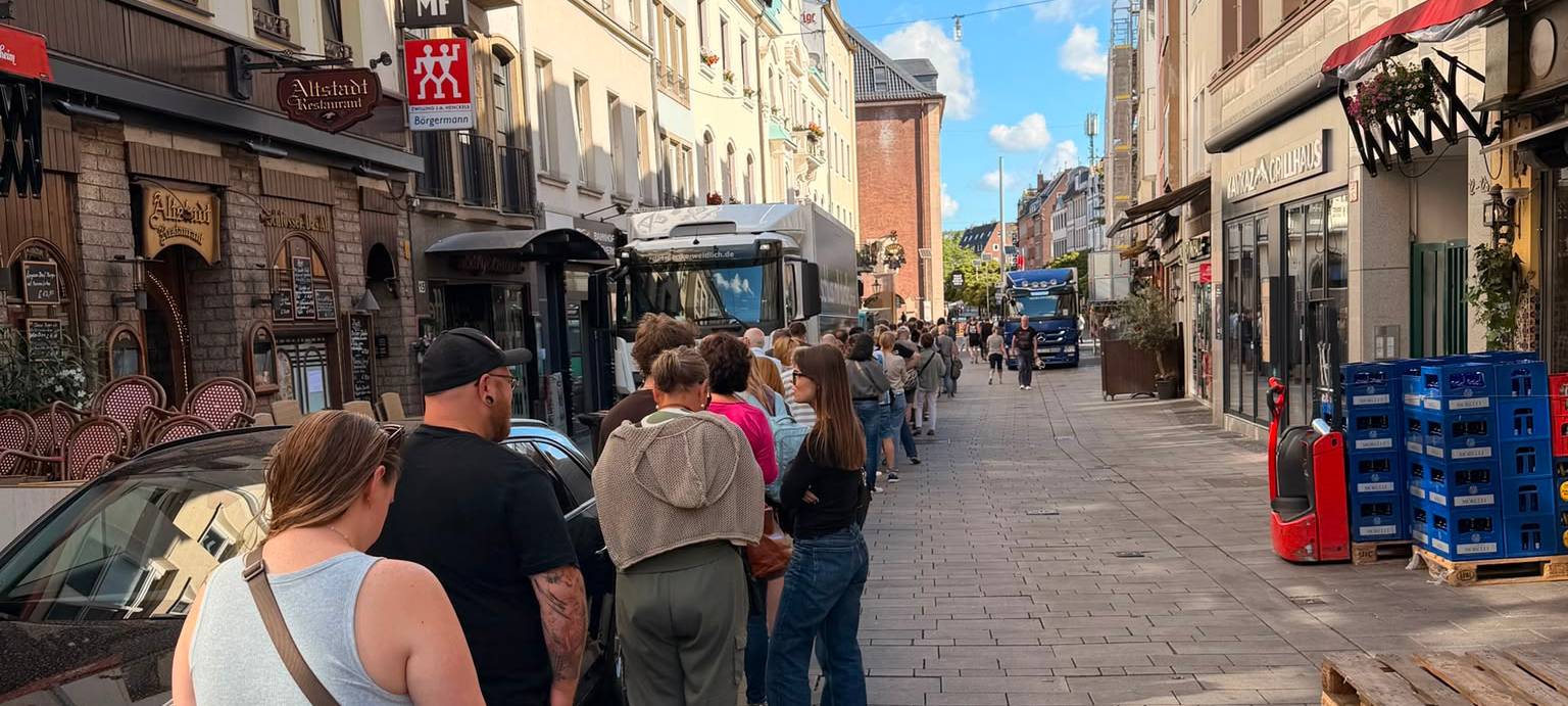 Menschen stehen in der Altstadt vor dem Pop-up-Store der Toten Hosen in der Schlange an