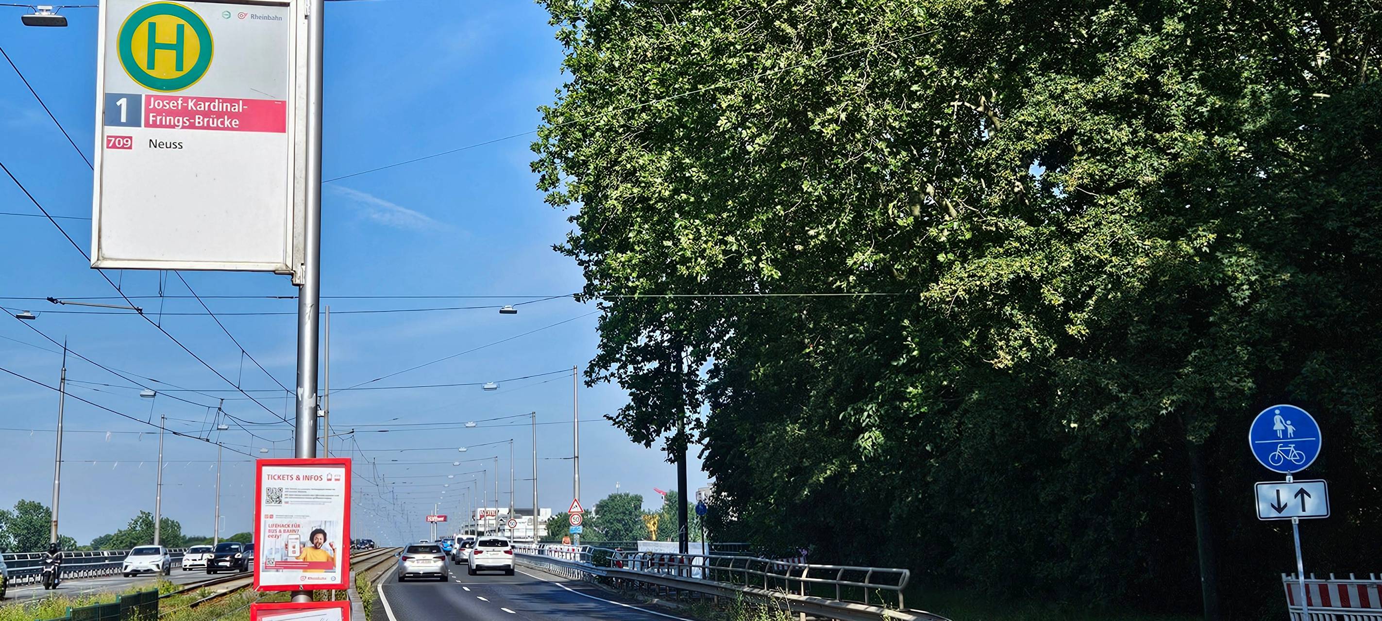 Josef-Kardinal-Frings-Brücke in Richtung Neuss im Vordergrund ein Haltestellenschild