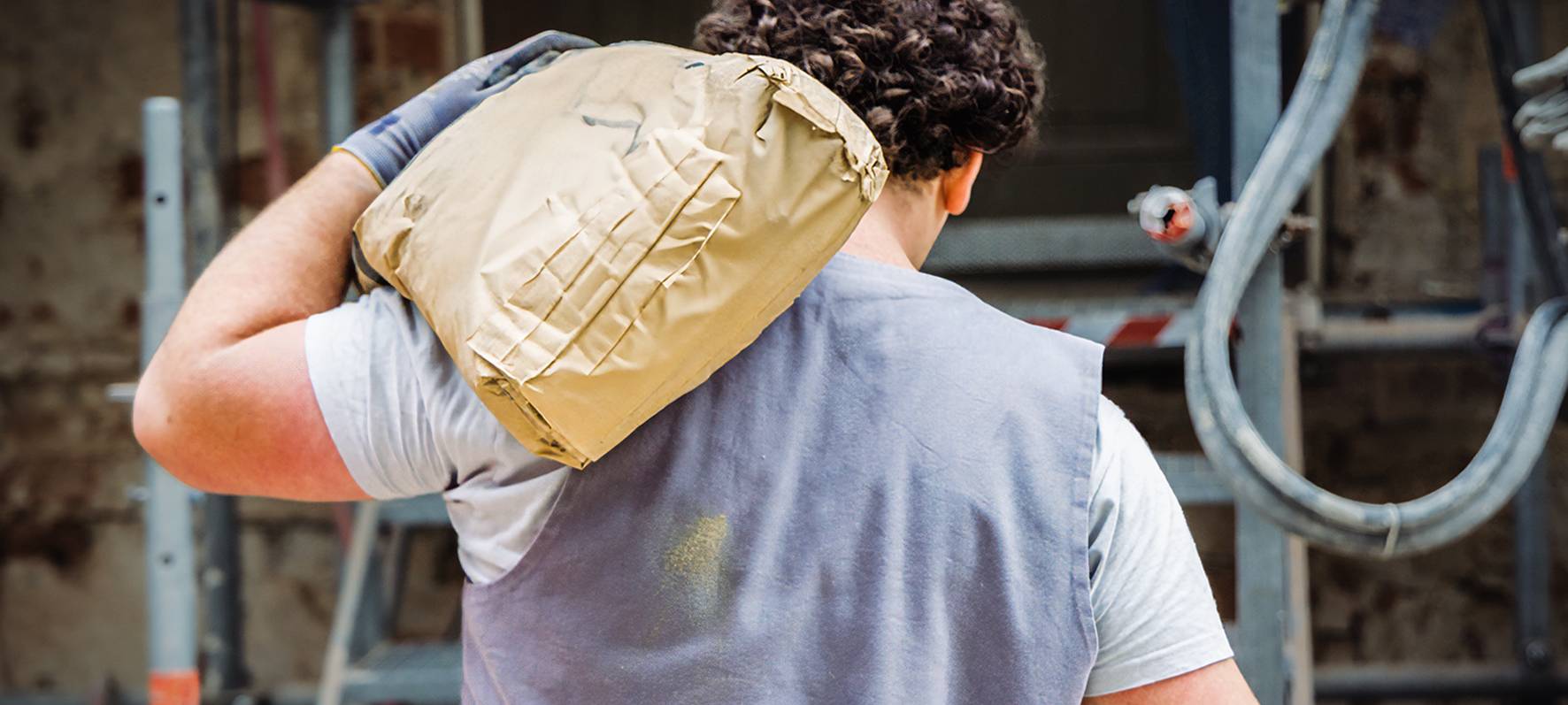 Ein Mann schleppt einen Sack über der linken Schulter