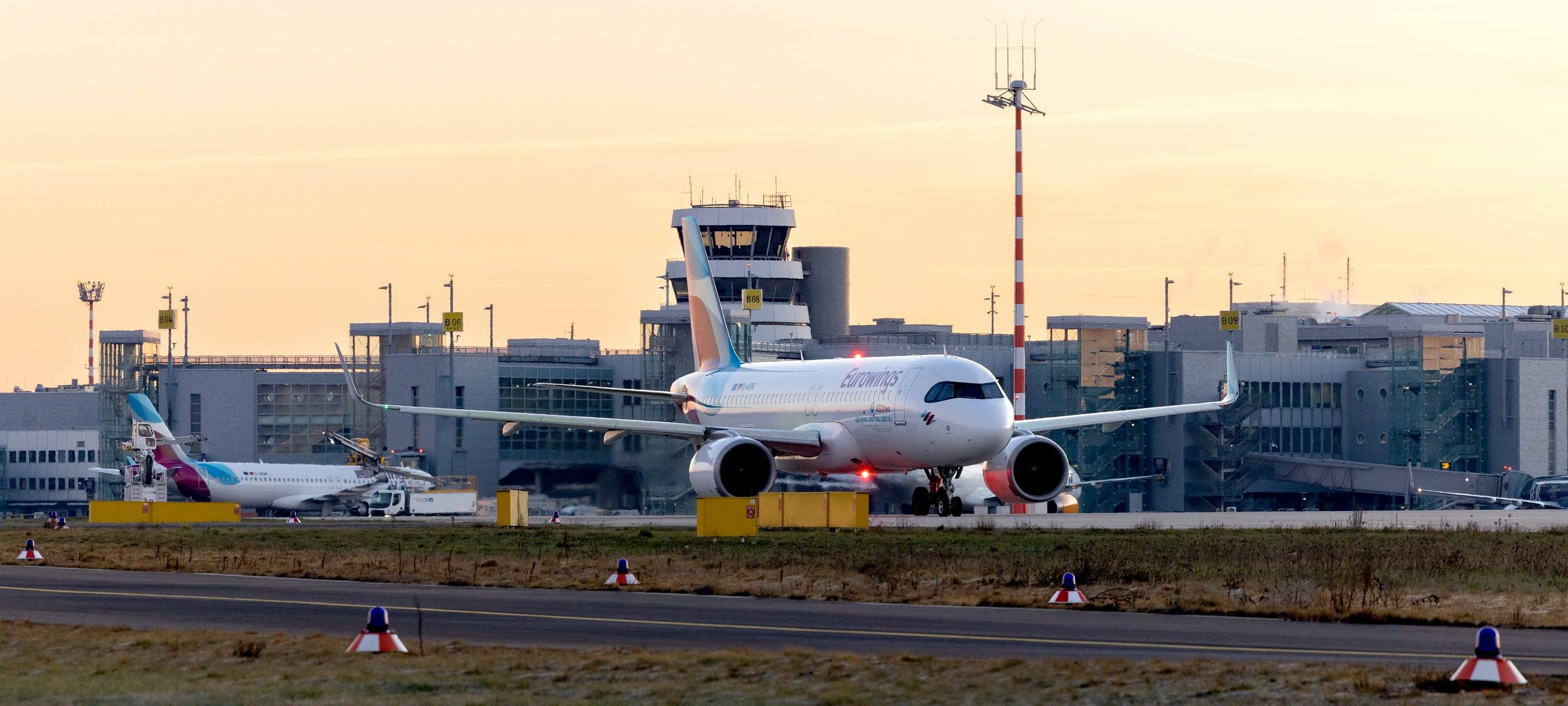 Eurowings Flugzeug auf der Rollbahn, im Hintergrund sieht man den Düsseldorfer Flughafen.