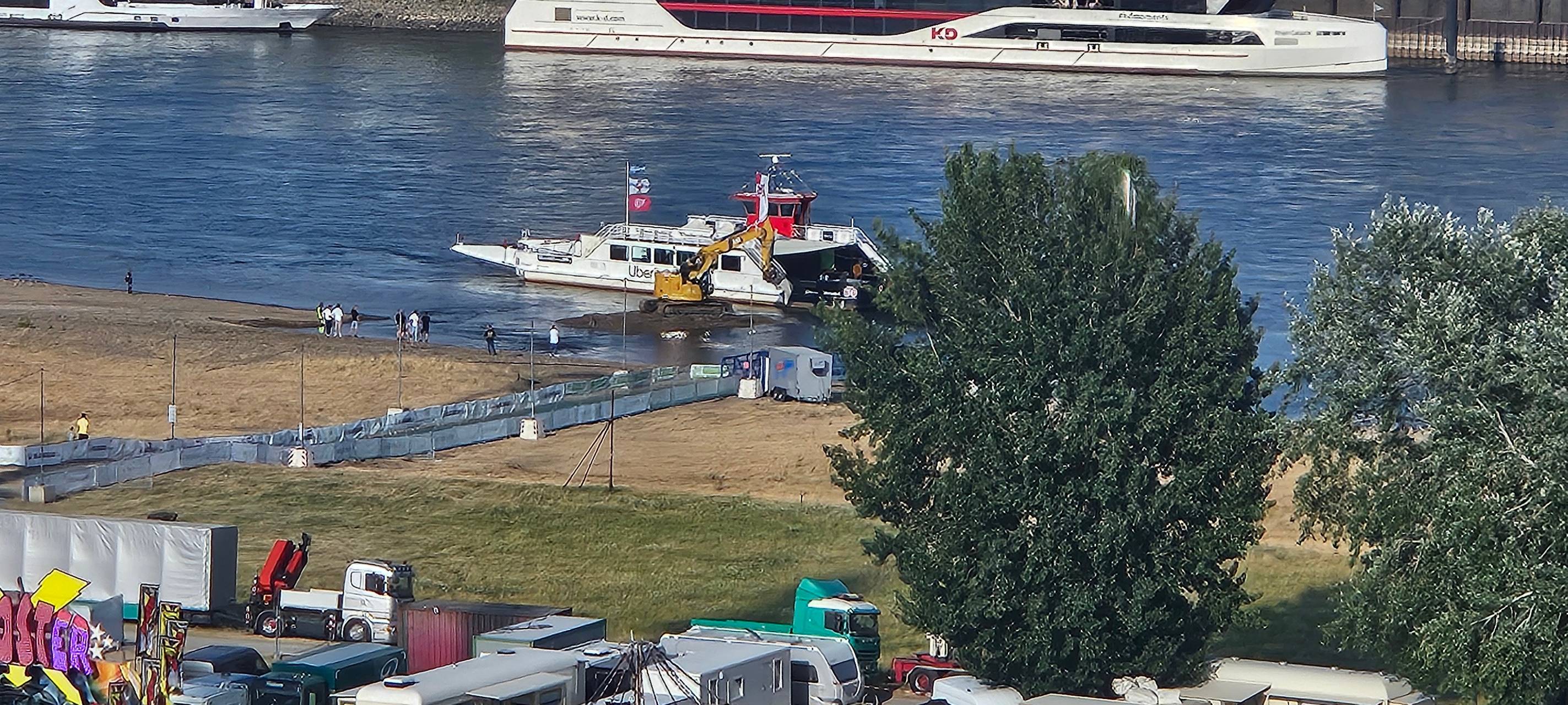 Kirmesfähre und Bagger im Rhein von oben.